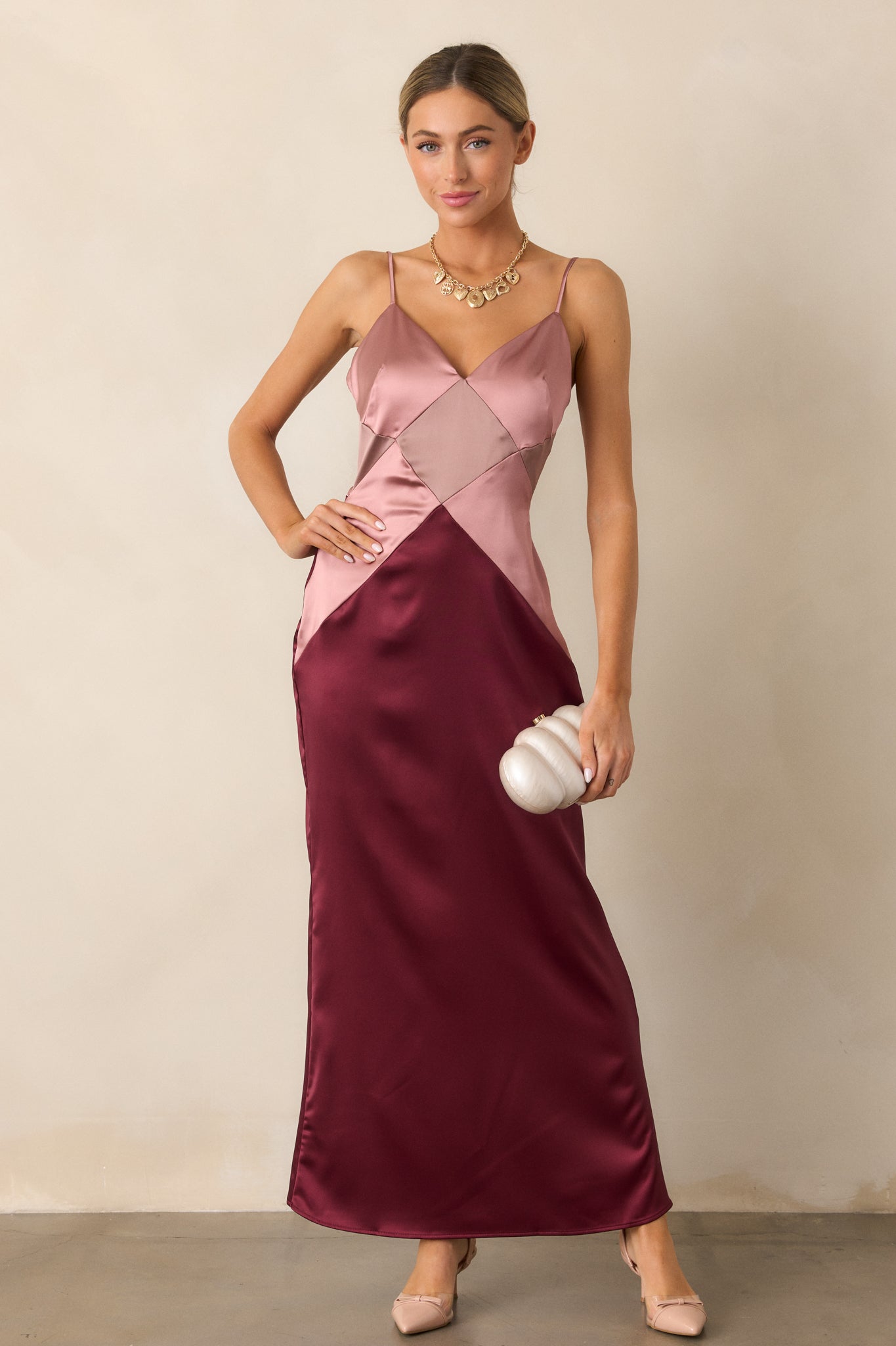 A full view of the dress emphasizing its flattering v-neckline, softly draped fabric, and the unique geometric detailing.