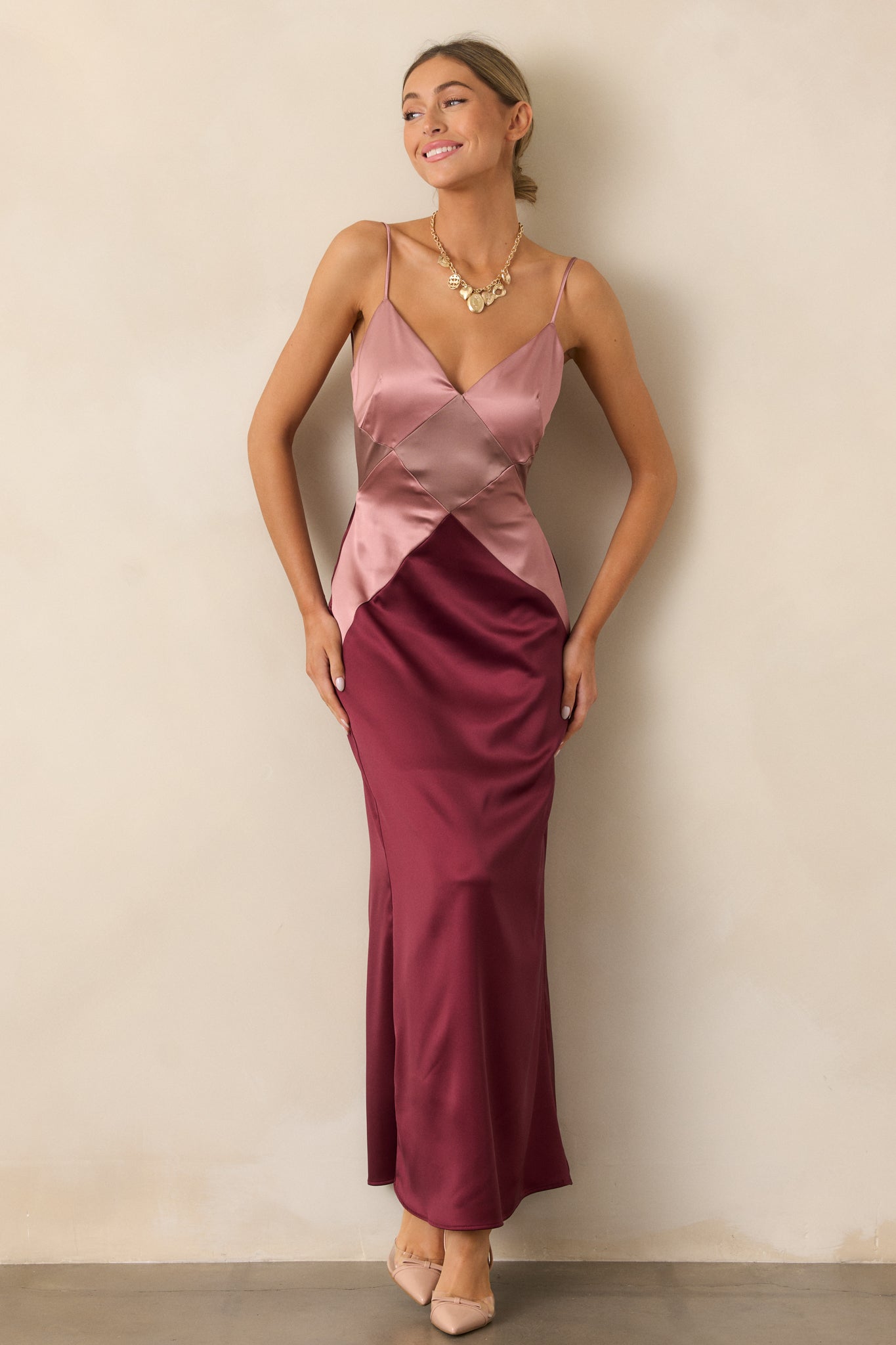 A full-length image of the mauve mist dress, highlighting its v-neckline, flowing silhouette, and bold diamond color-blocked design.