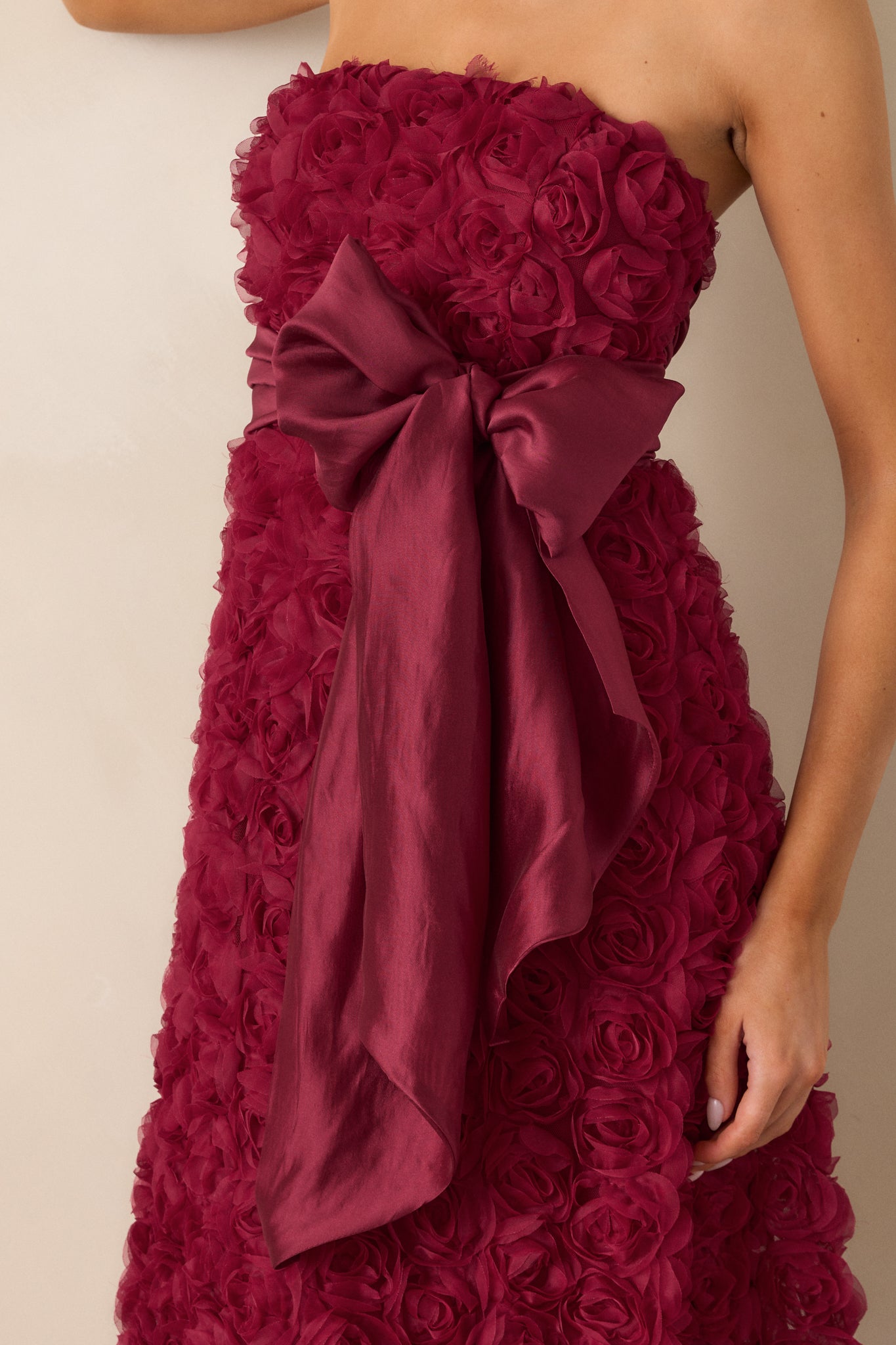 A close-up of the floral applique, capturing the texture and intricacy of the detailing on the wine-colored fabric.