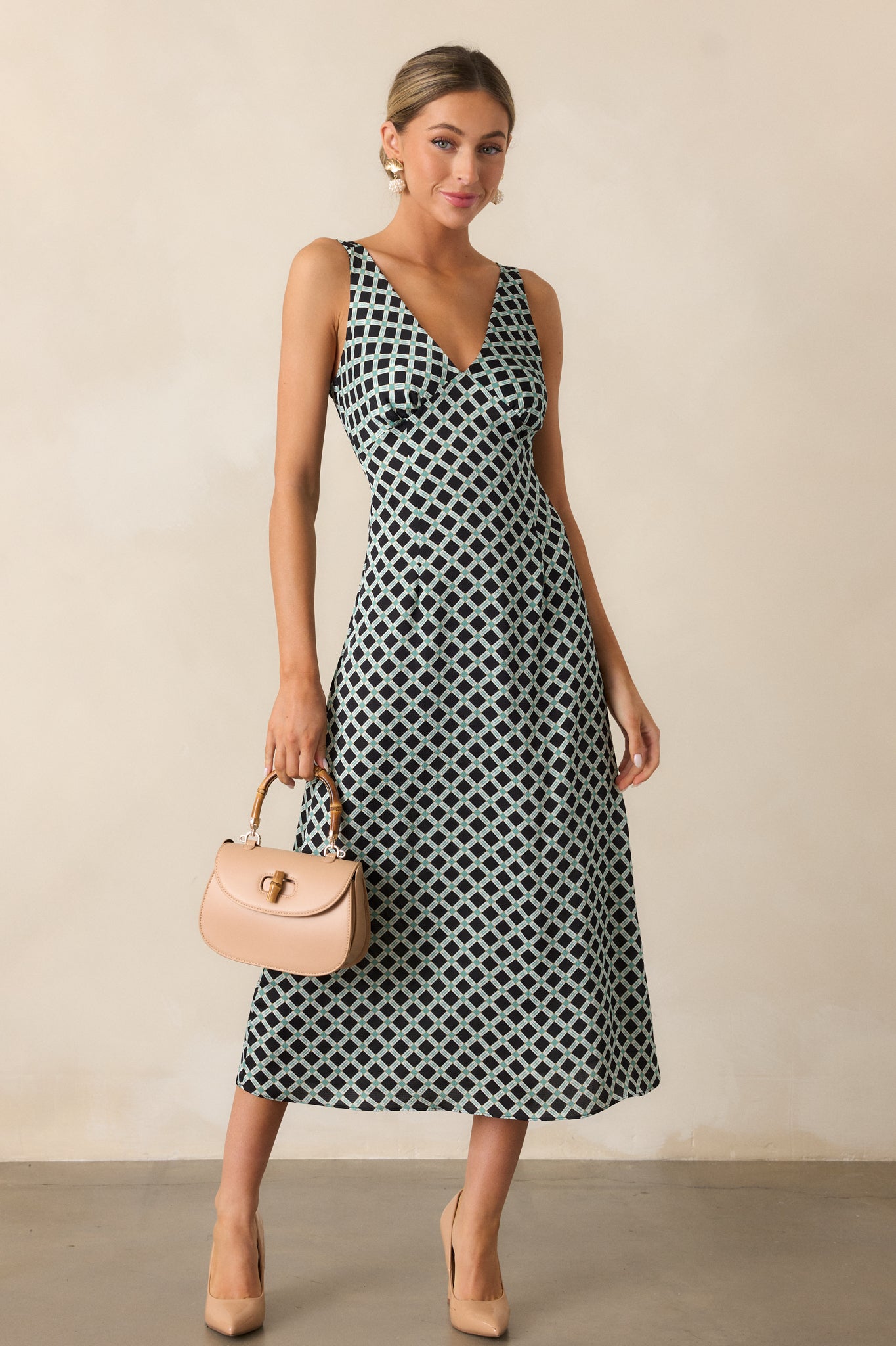 Full-length image emphasizing the relaxed fit and draping effect of the black dress's midi length and printed design.