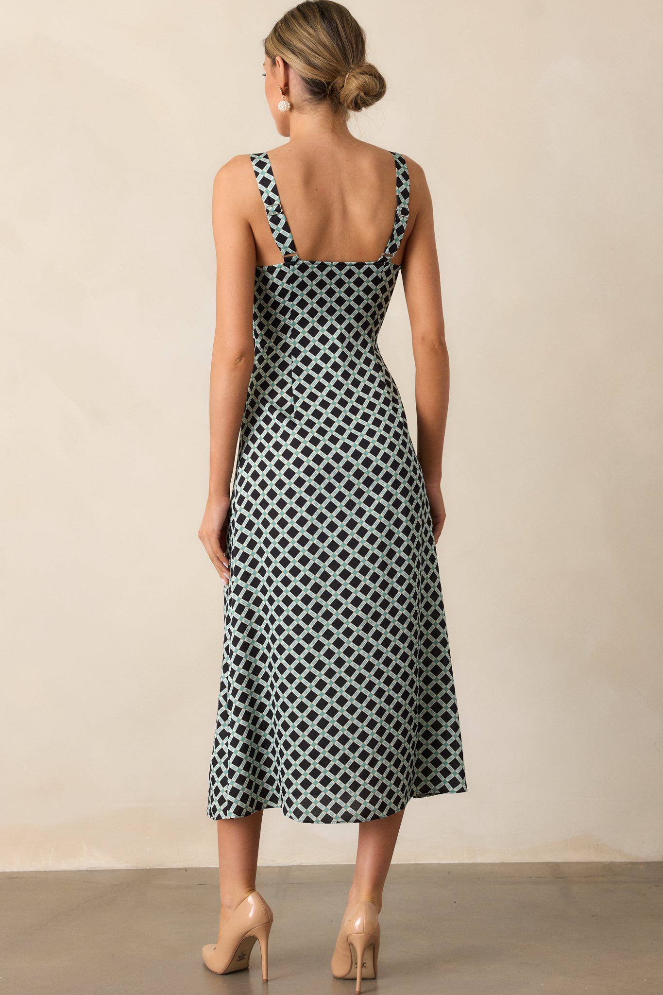 Back view of the black dress highlighting the adjustable shoulder straps and the continuous geometric print across the back panel.