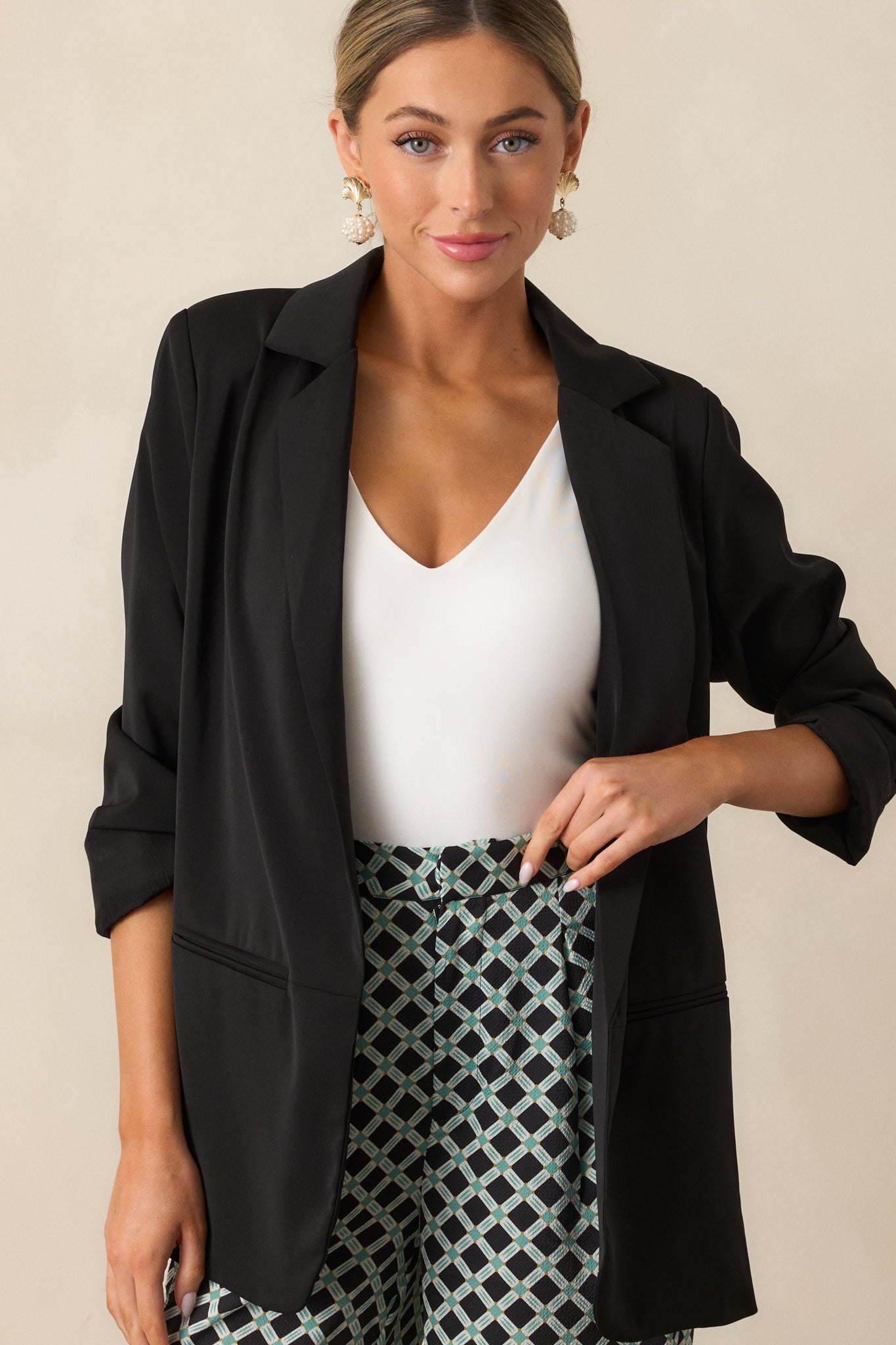 Zoomed-in crop focusing on the blazer’s front pocket detail and sleek tailoring.