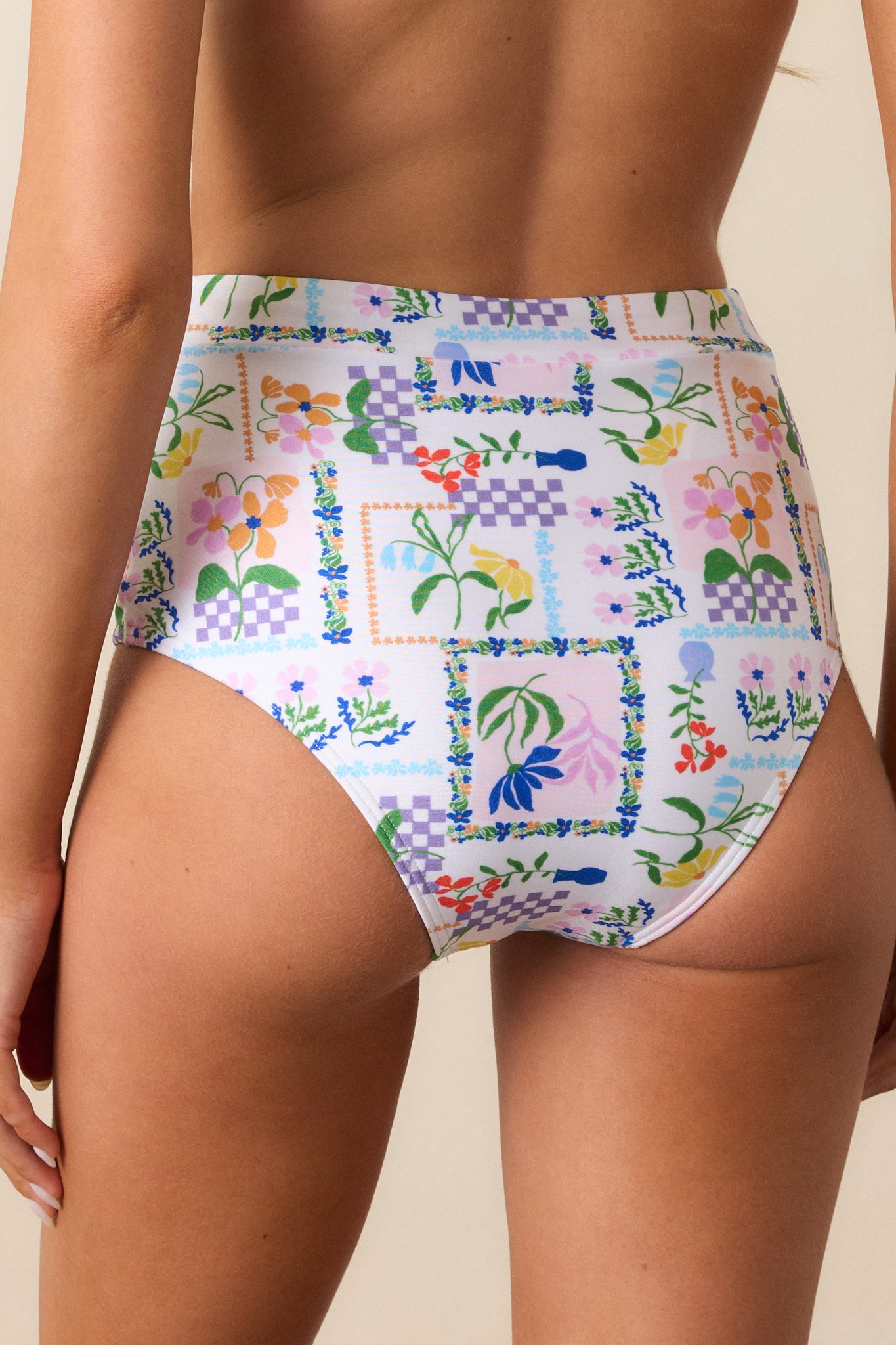 A back view of the ivory bikini bottom, highlighting its cheeky cut and high-waisted design.