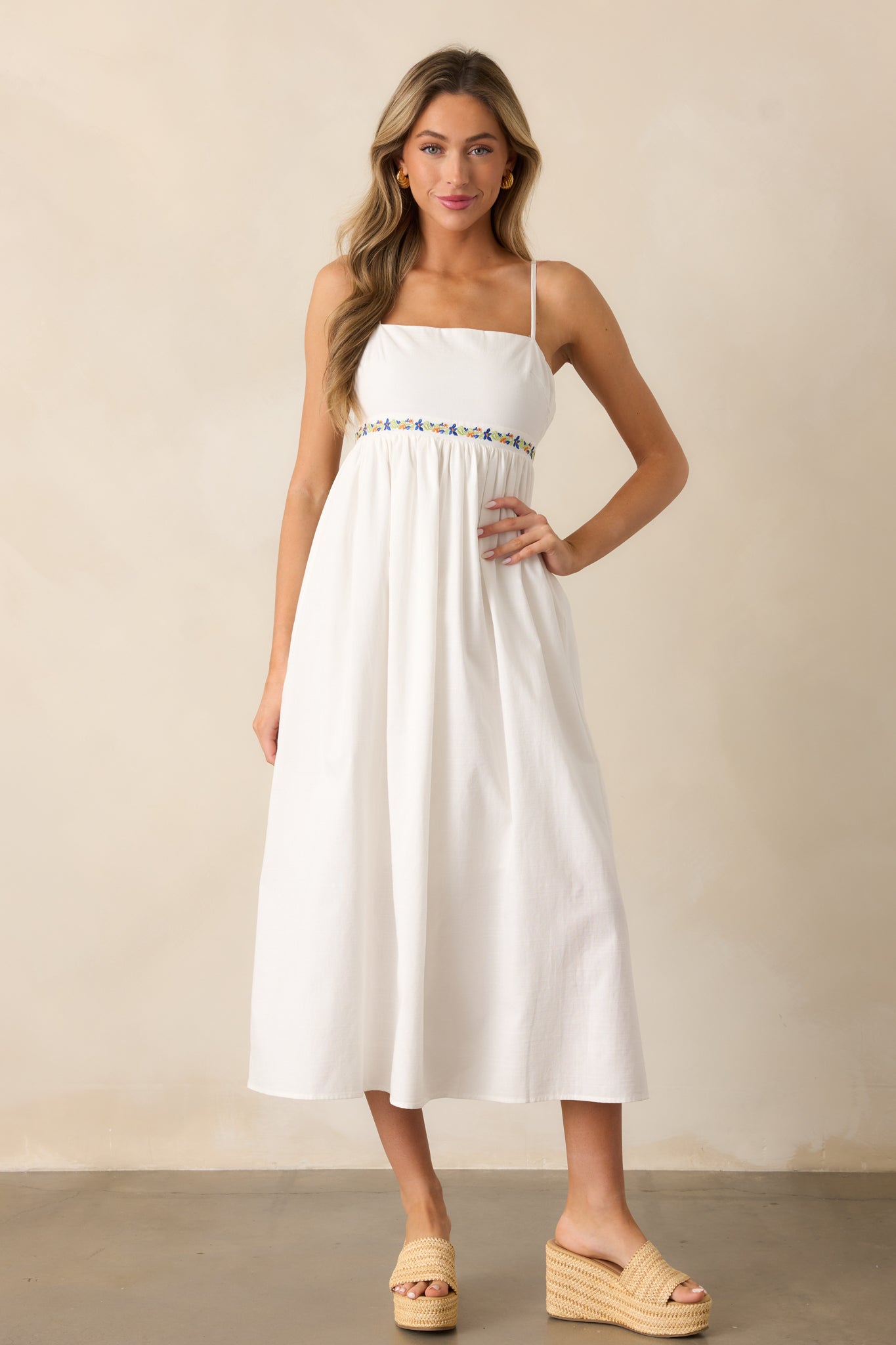 Full-length shot of the ivory dress with a square neckline, relaxed skirt, and delicate floral embroidery under the bust.