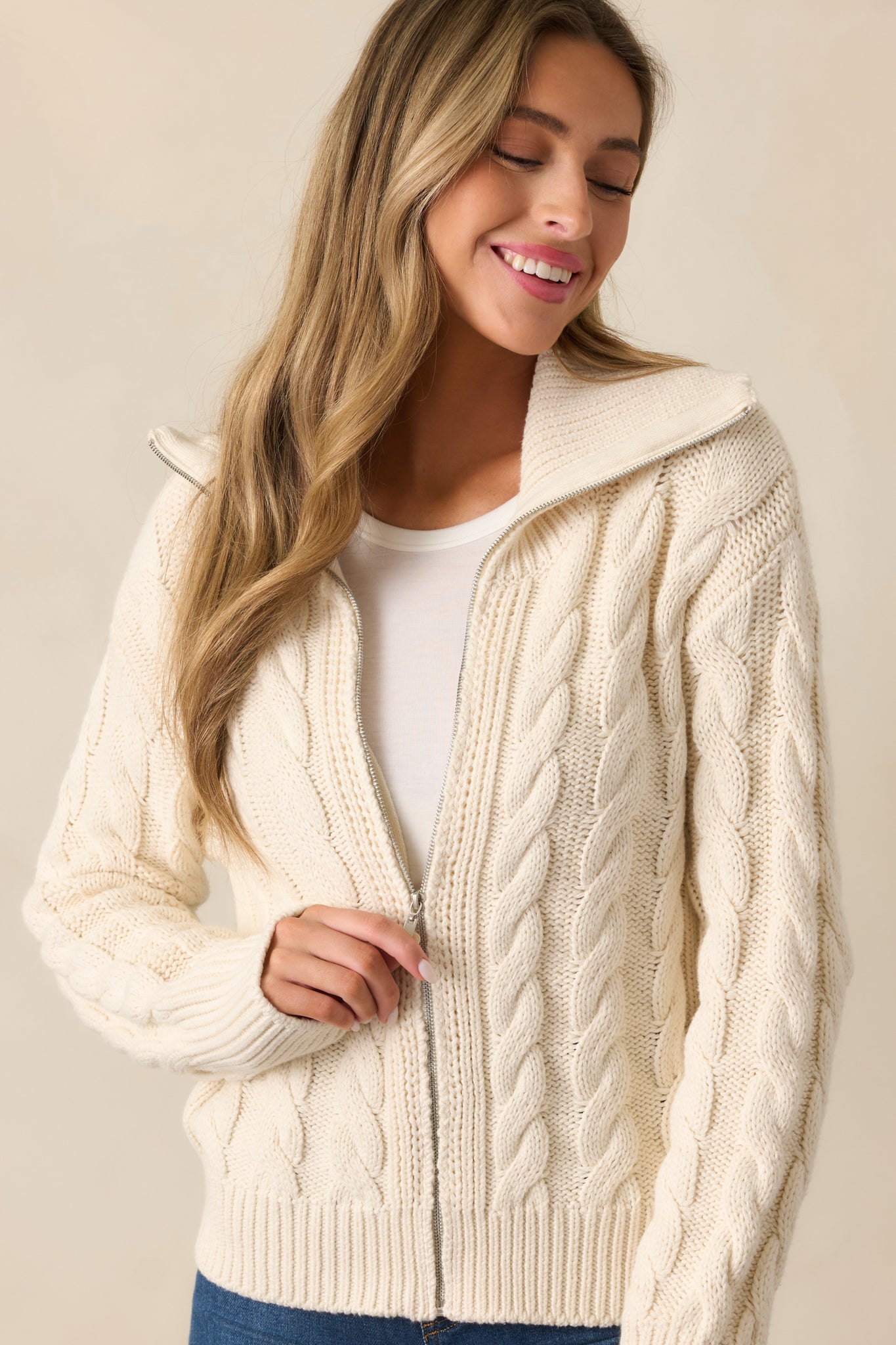 A detailed shot of the silver zipper front on the ivory seasalt cardigan, highlighting the clean finish and textured knit fabric.