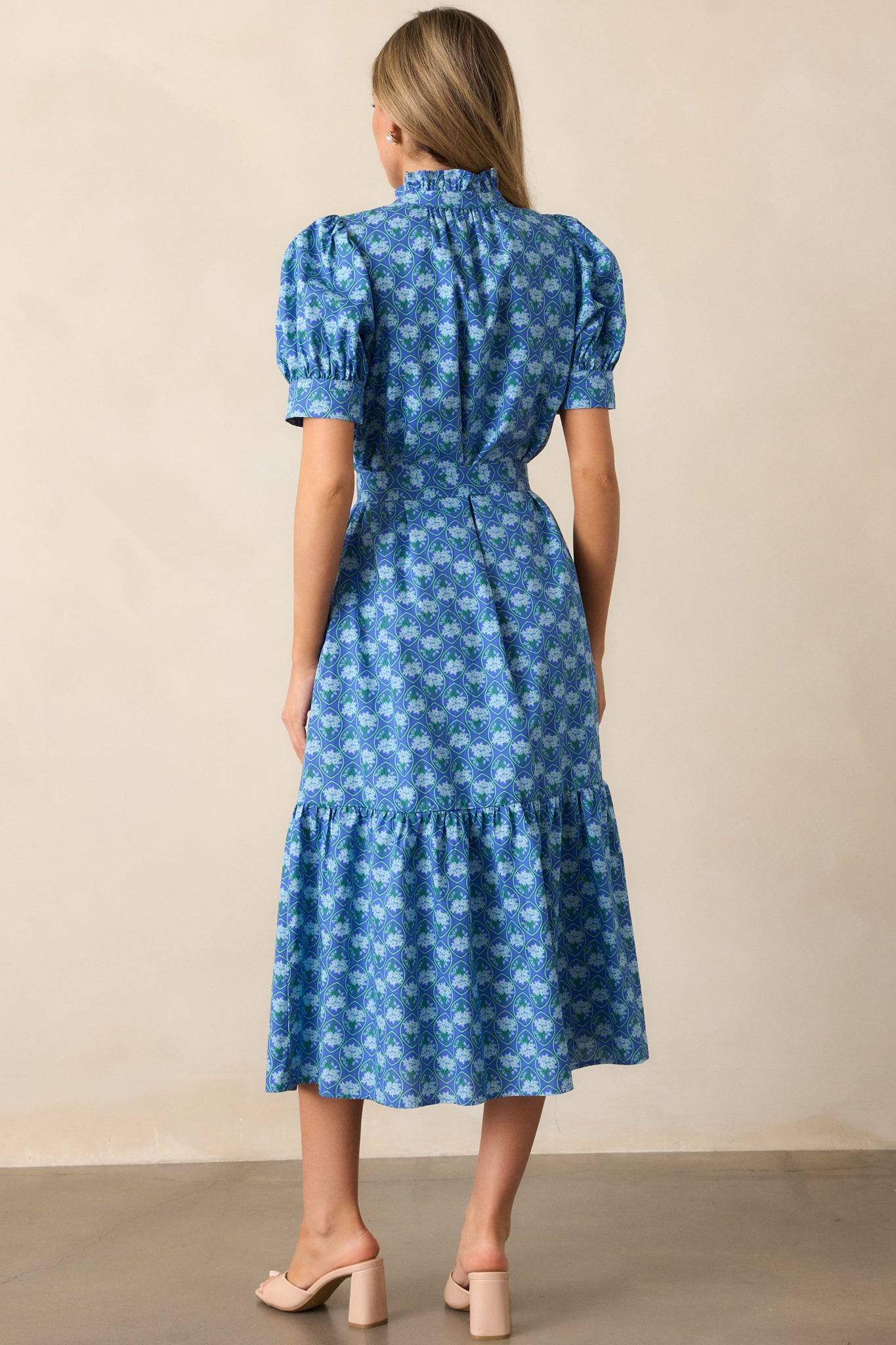 A back view of the blue dress, highlighting the button front design and tiered skirt.