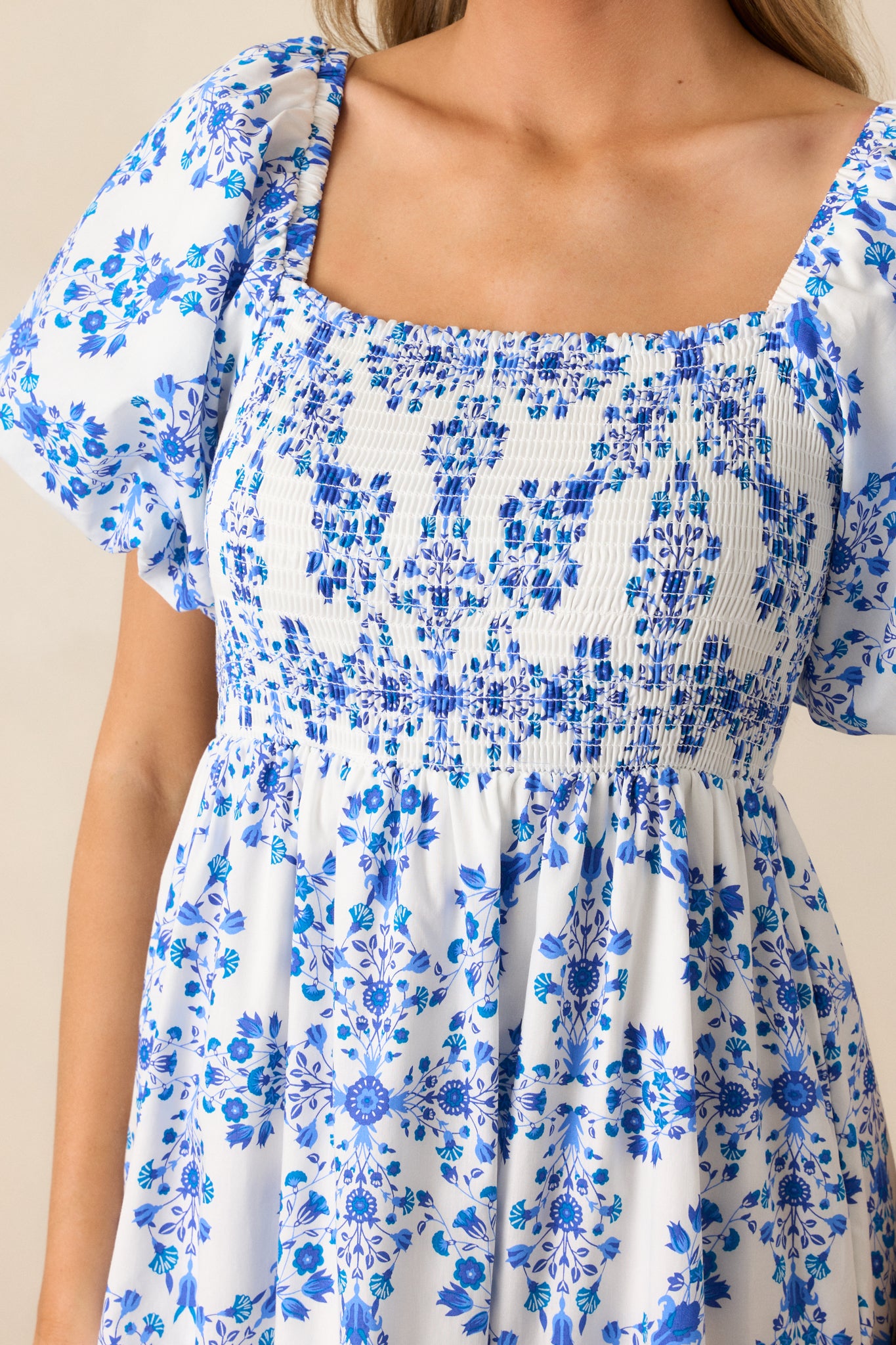 An up-close shot of the intricate floral pattern and smocked top of the royal blue maxi dress.