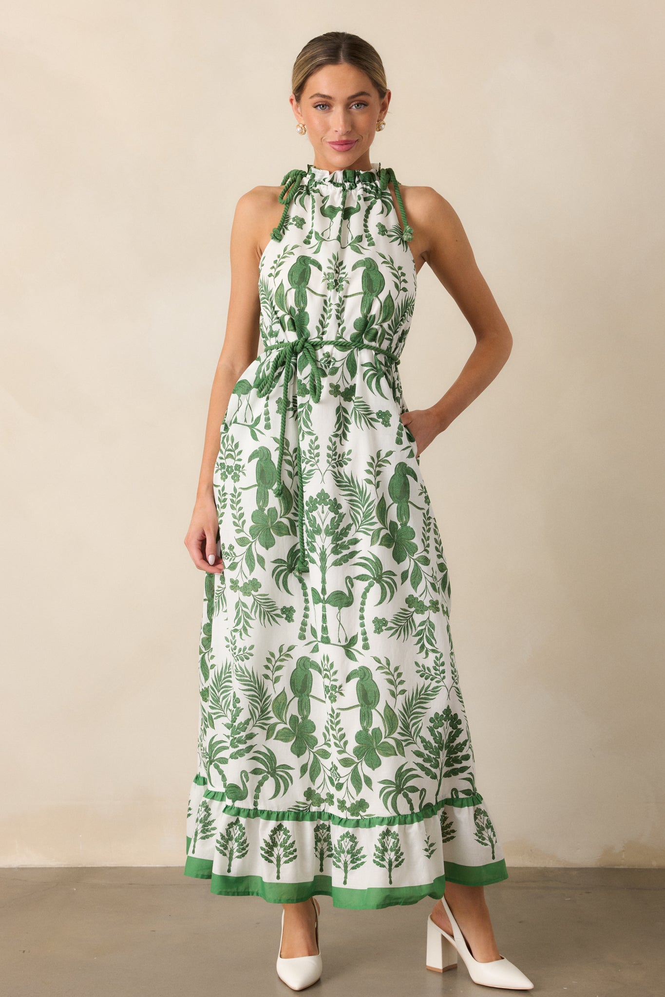 The green dress in a full-length shot, featuring a self-tie rope waistband, tiered bottom, and tropical pattern.