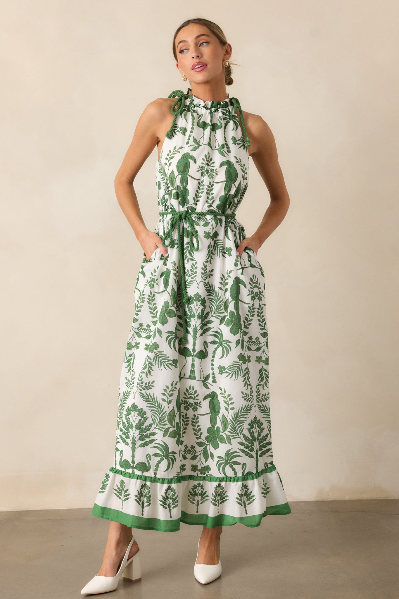 The green dress in a full-body shot, highlighting the self-tie cinch rope accent, tropical design, and tiered skirt.