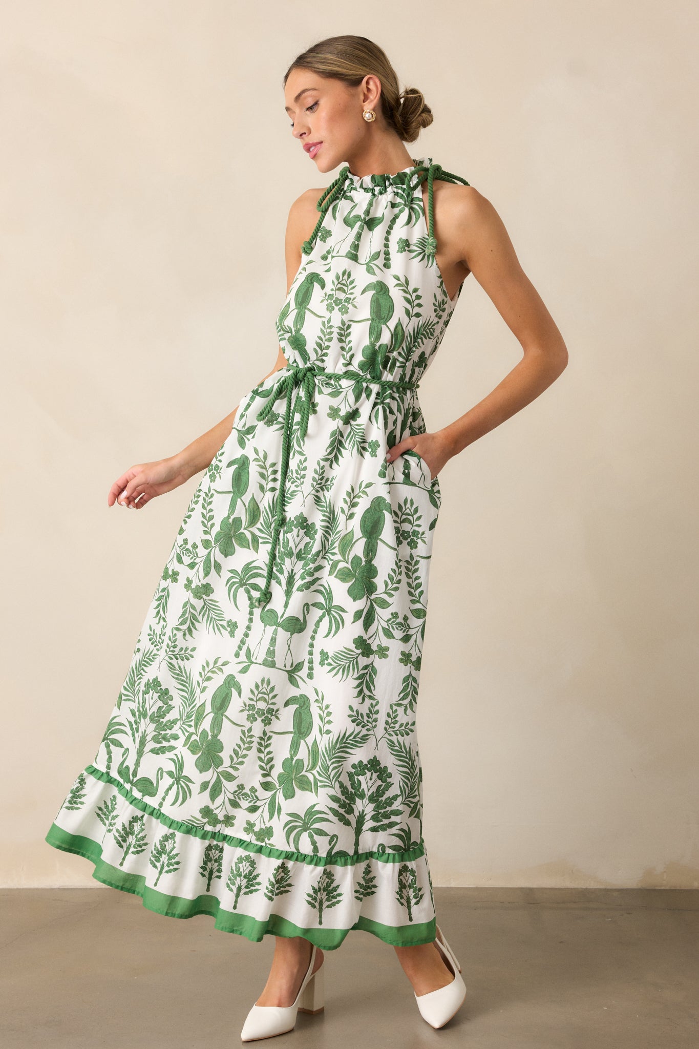 Full view of the green dress with a halter neckline, self-tie rope waistband, and tiered bottom in maxi length.