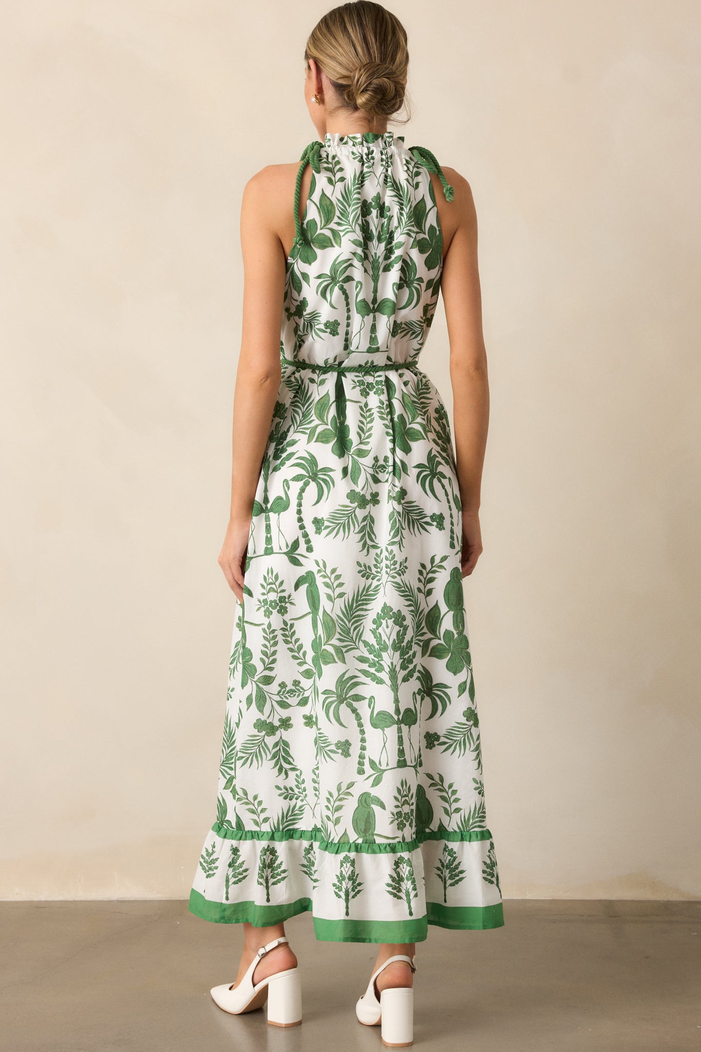 A back view of the green dress, highlighting the self-tie rope waistband and flowing tiered bottom.