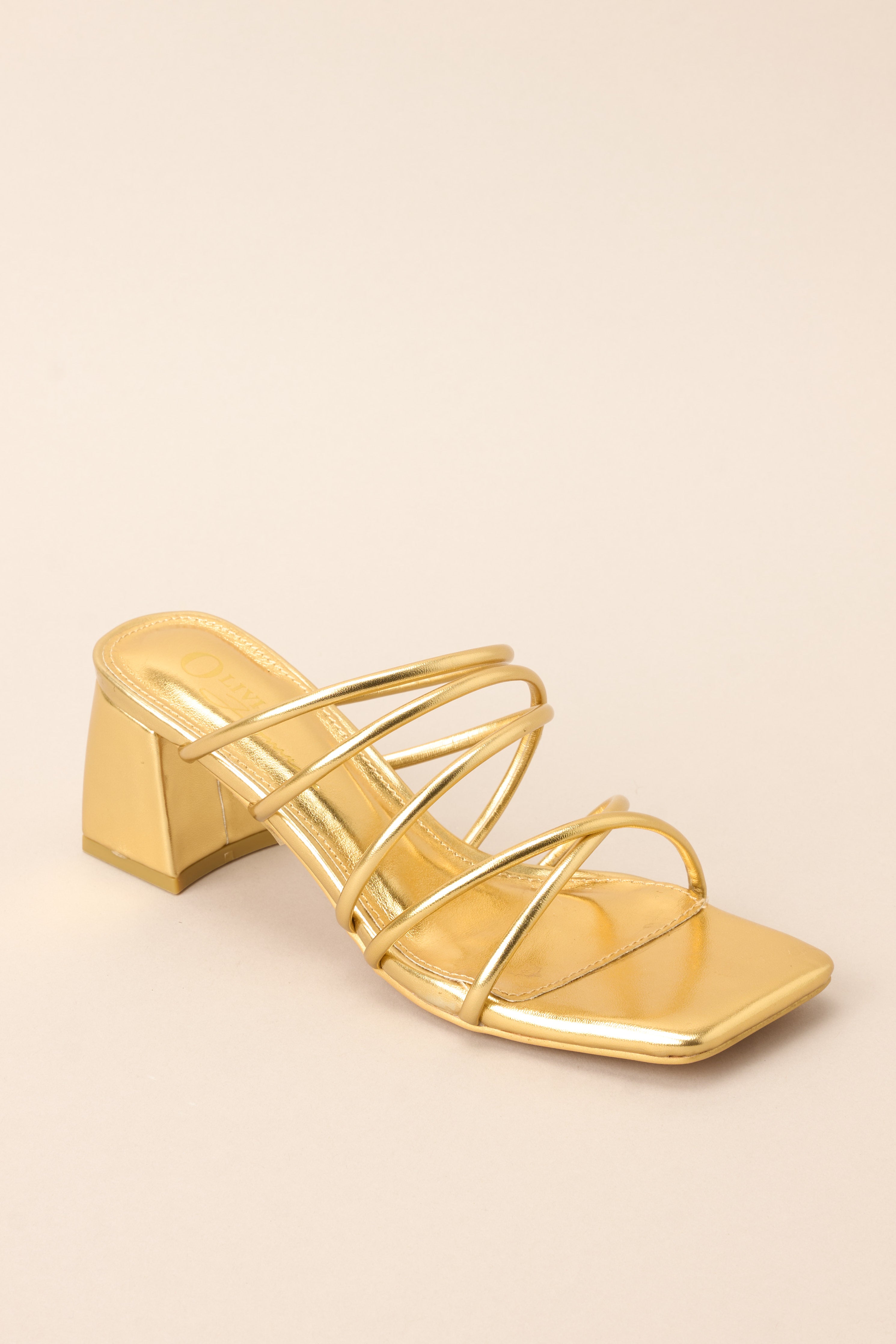 Outer-side view of these heels that feature a rounded toe, a slip-on design crisscross straps across the top of the foot, and a short, thick heel.