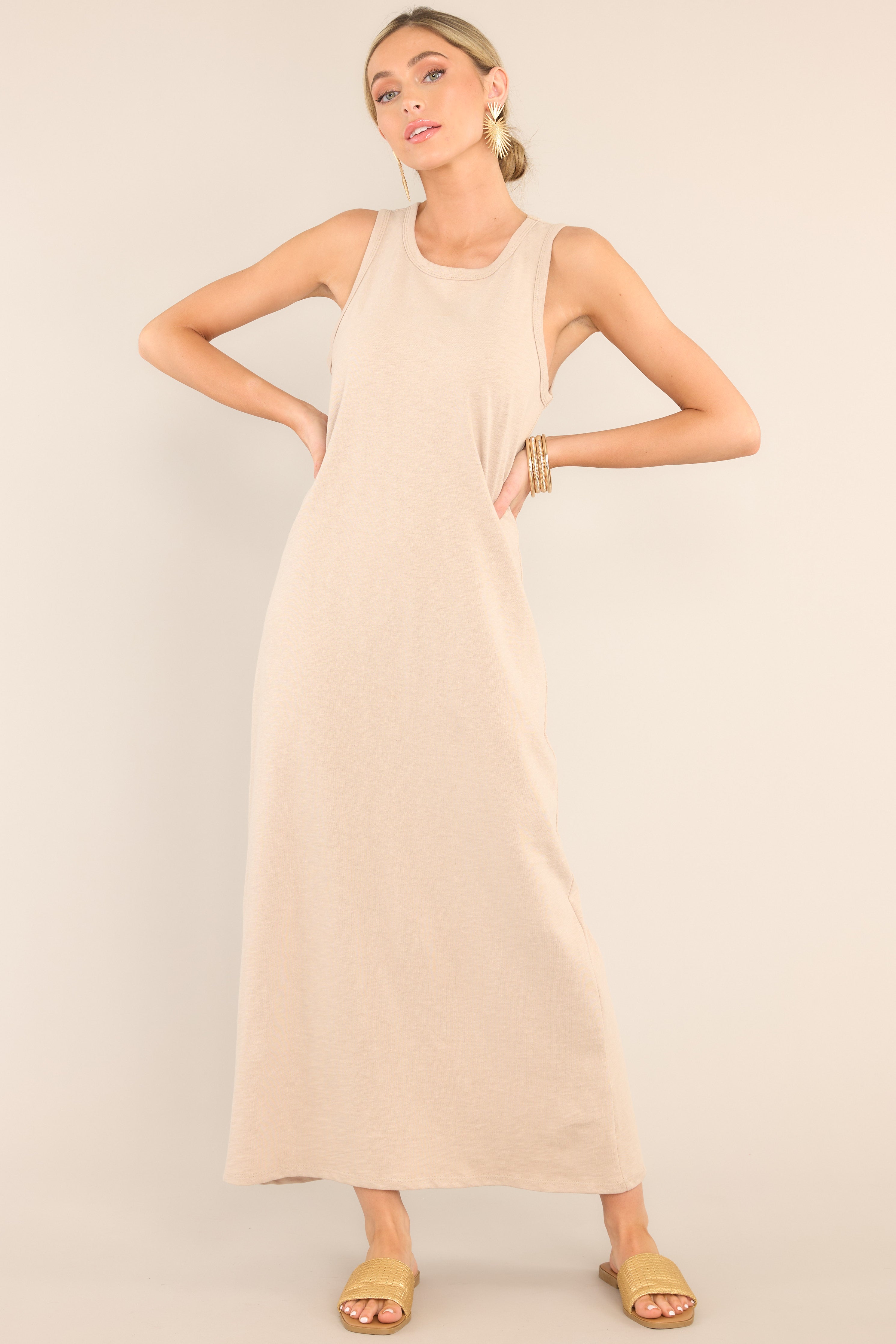 This tan dress features a crew neckline, a straight silhouette, and a slightly stretchy cotton material that gives it a relaxed fit. 