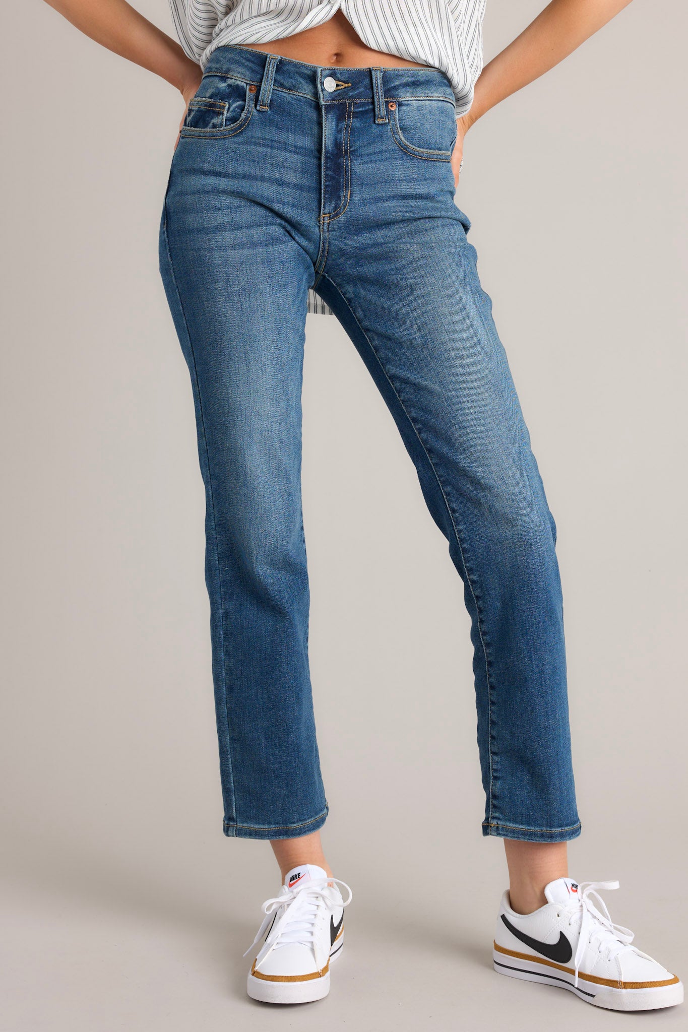 Close up front view of these jeans that feature a zipper and button closure, belt loops, 5 functional pockets, and a straight leg design.