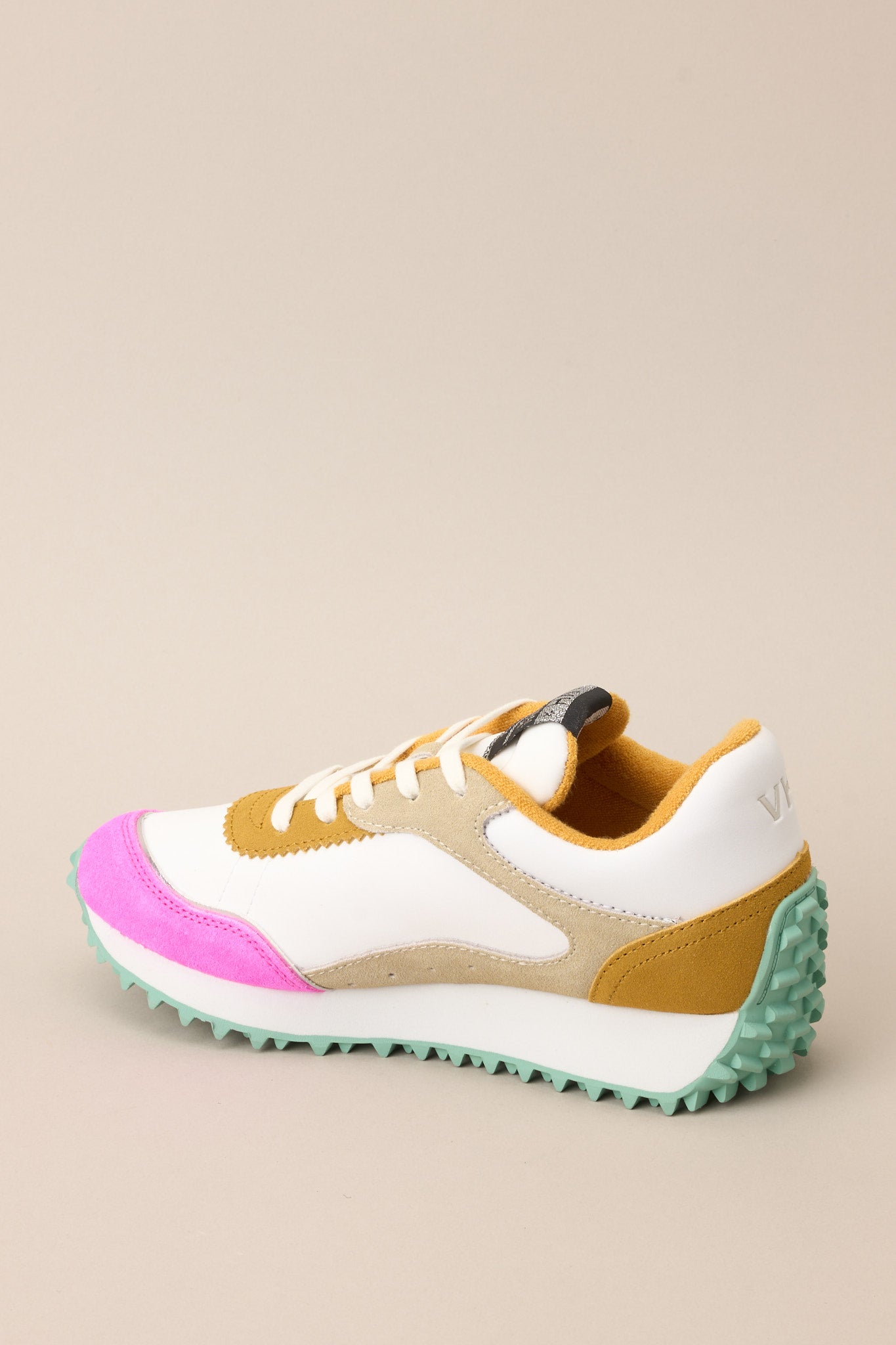 Inner-side view of these sneakers that feature a rounded toe, functional laces, pops of color, a slight platform, and a heavily textured sole.