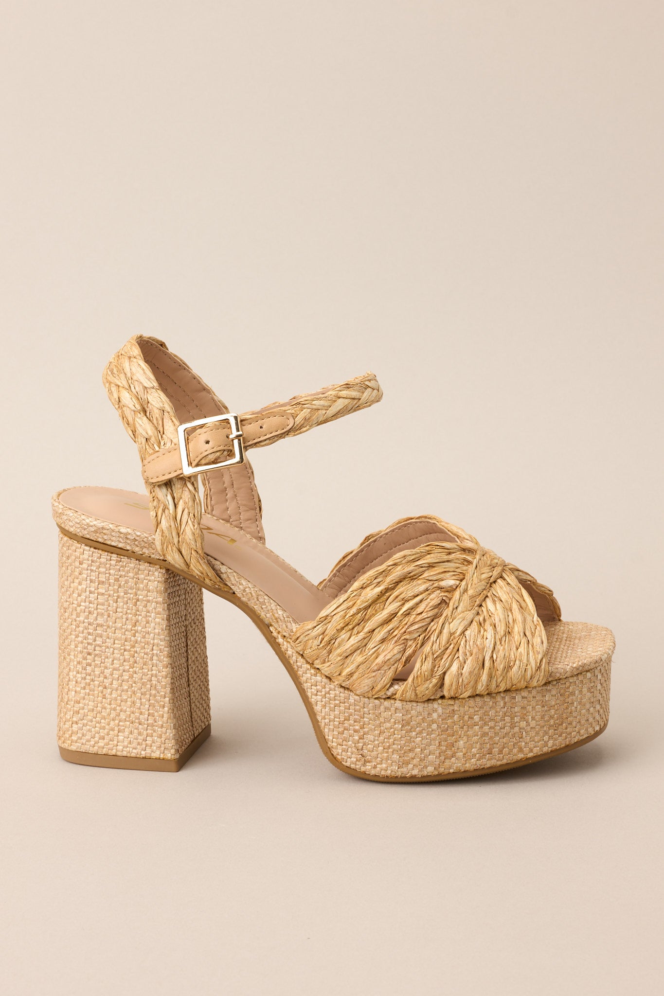 Outer-side view of these sandals that feature a wide strap over the top of the foot, a strap around the ankle with a classic buckle closure, a platform, and a chunky heel.