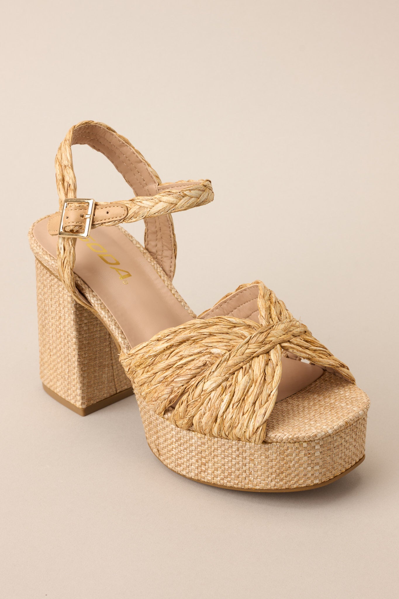 Angled side view of these sandals that feature a wide strap over the top of the foot, a strap around the ankle with a classic buckle closure, a platform, and a chunky heel.