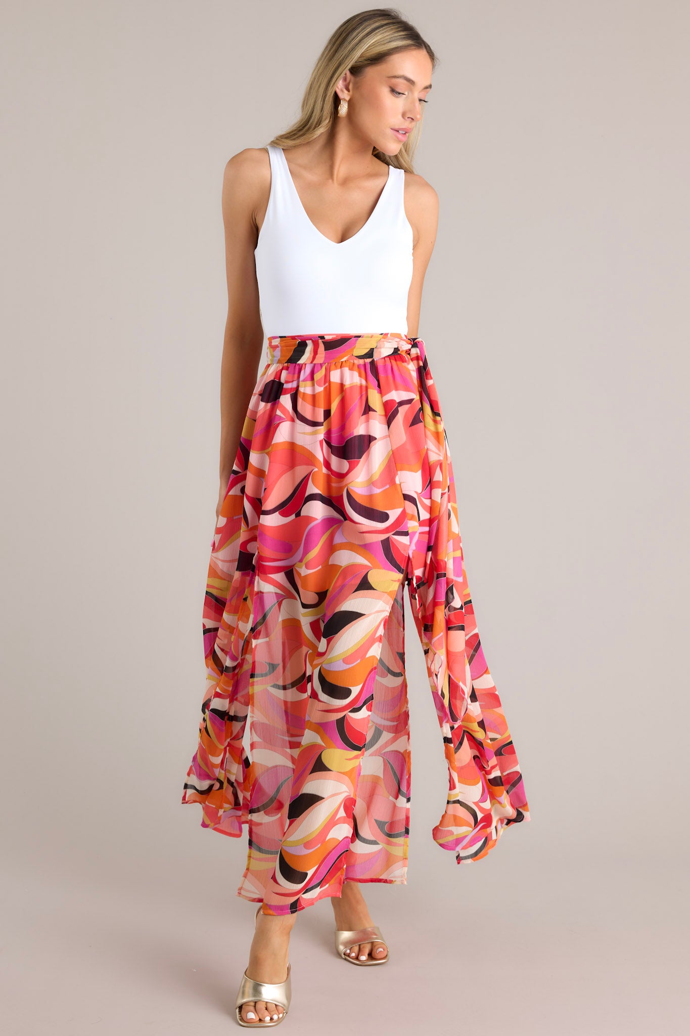 Front view of this skirt that features a high-waist design, a self-tie wrap around belt, an elastic section at the back of the waistband, and slits up the leg on either side of the skirt.