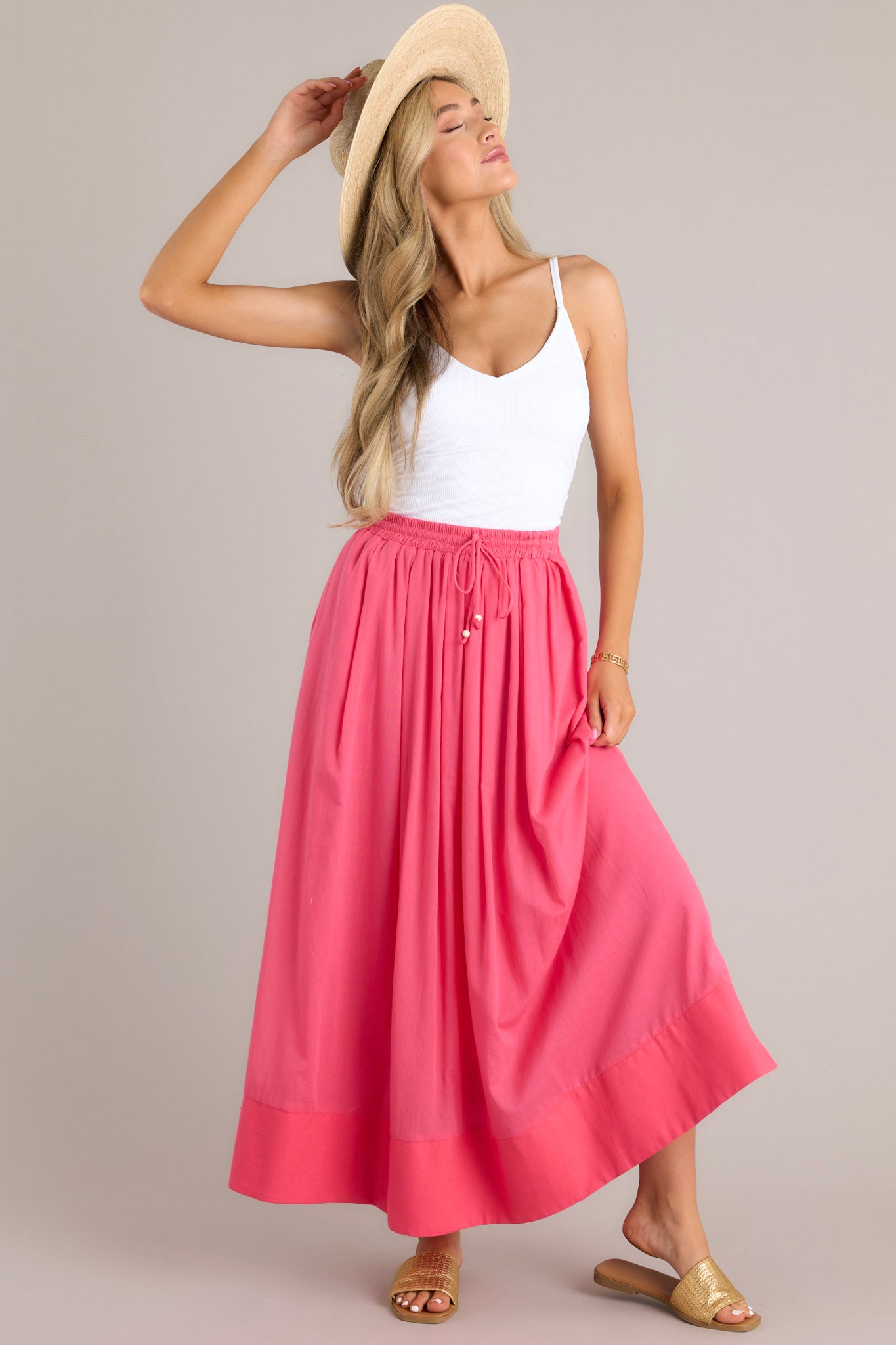 Full body view of this skirt that features a high waisted design, an elastic waistband, a self-tie drawstring, functional pockets, flowing fabric, and a thick hemline.