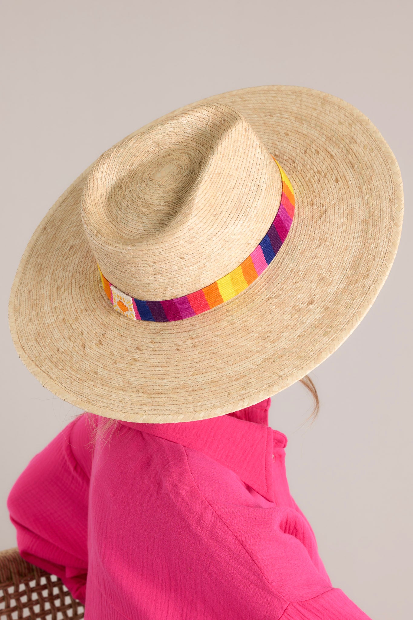 This palm hat features a cotton woven band with multicolor polka dots, and is handmade with palm fronds.