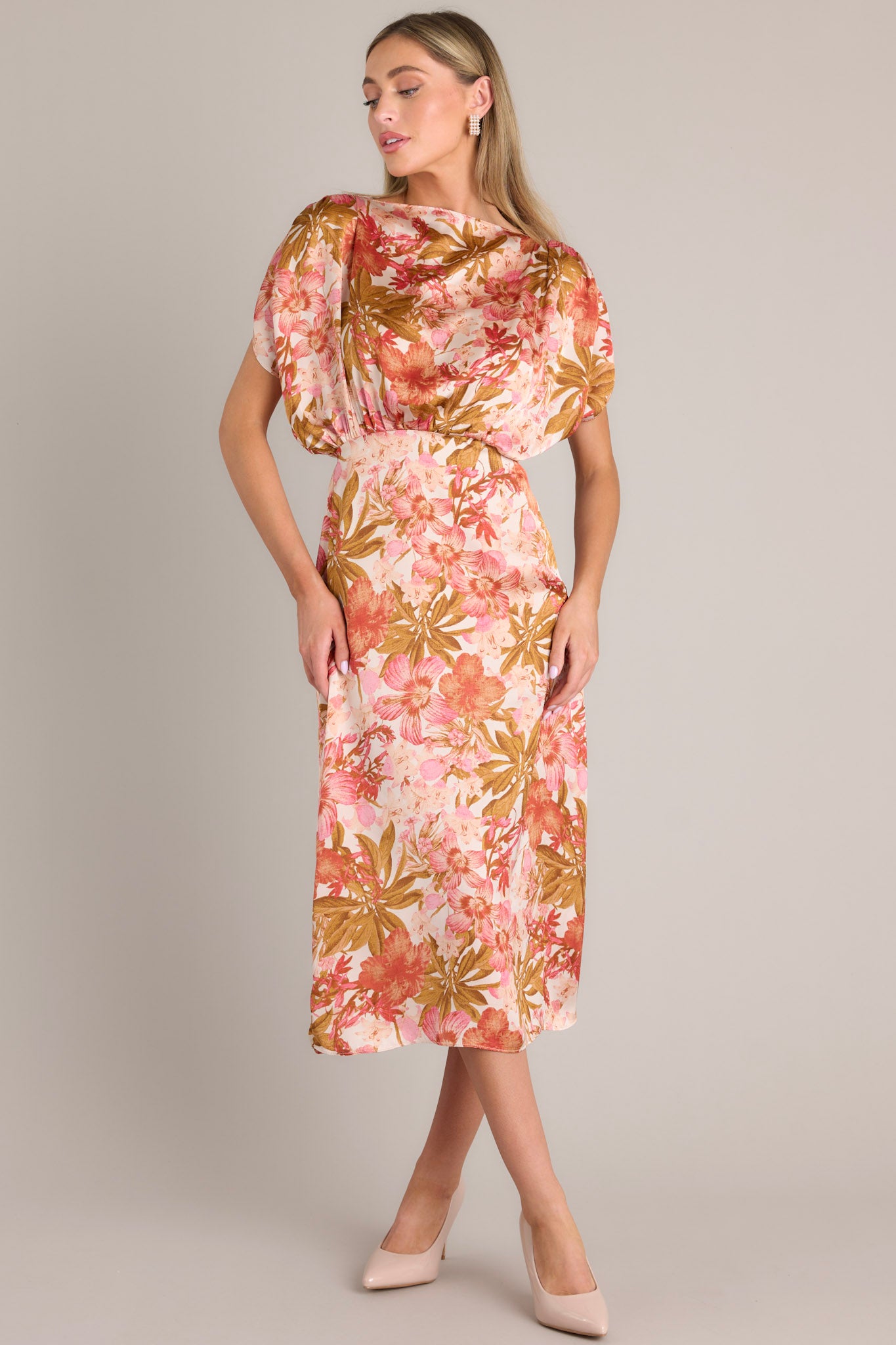 A knee-length rose pink dress with a boat neckline, gathered waist, elastic insert in the back, discreet side zipper, side slit, and wide sleeves.