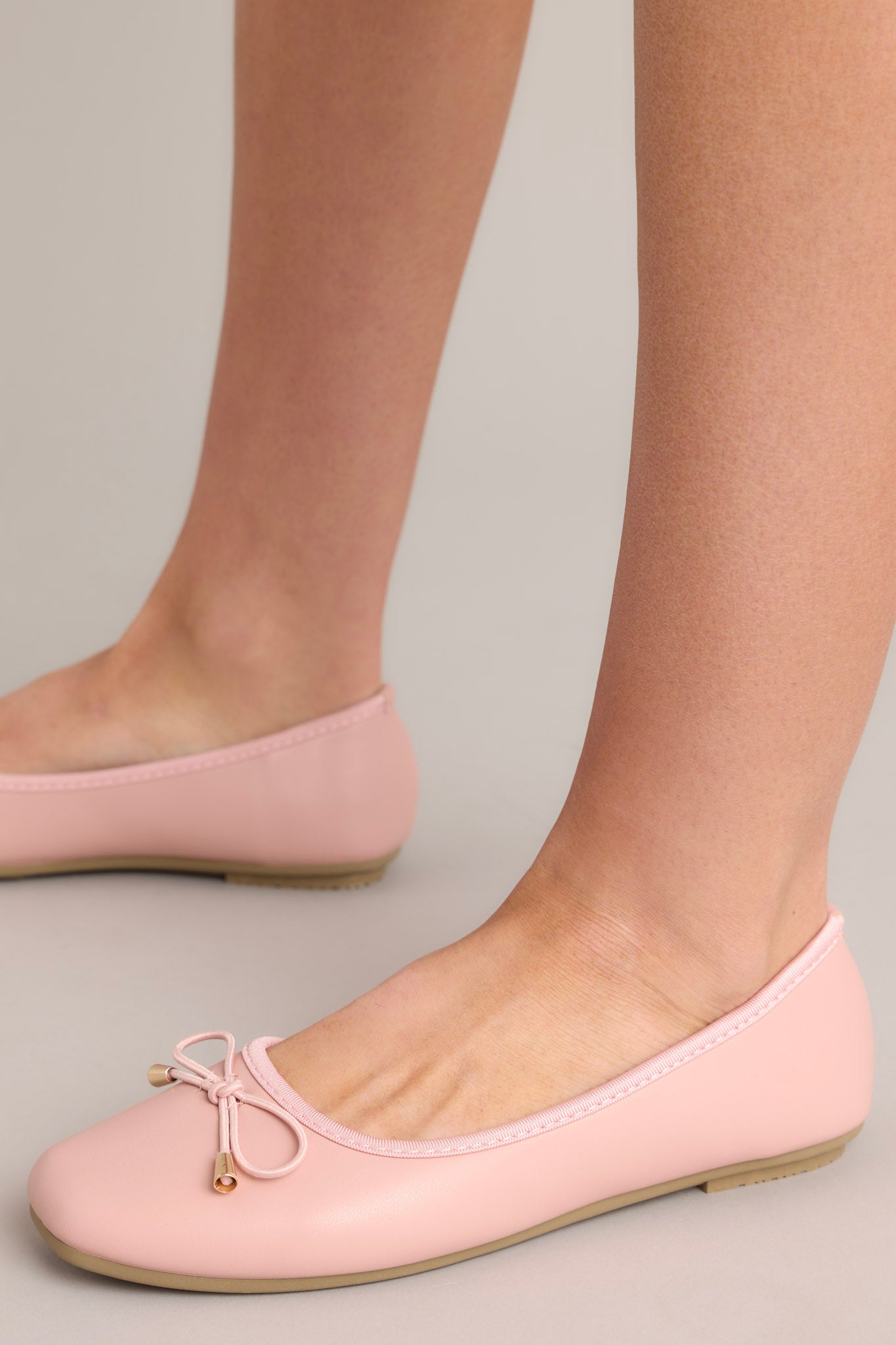 These pink flats feature a square toe, a bow detail, a matte finish, and a memory foam insole.