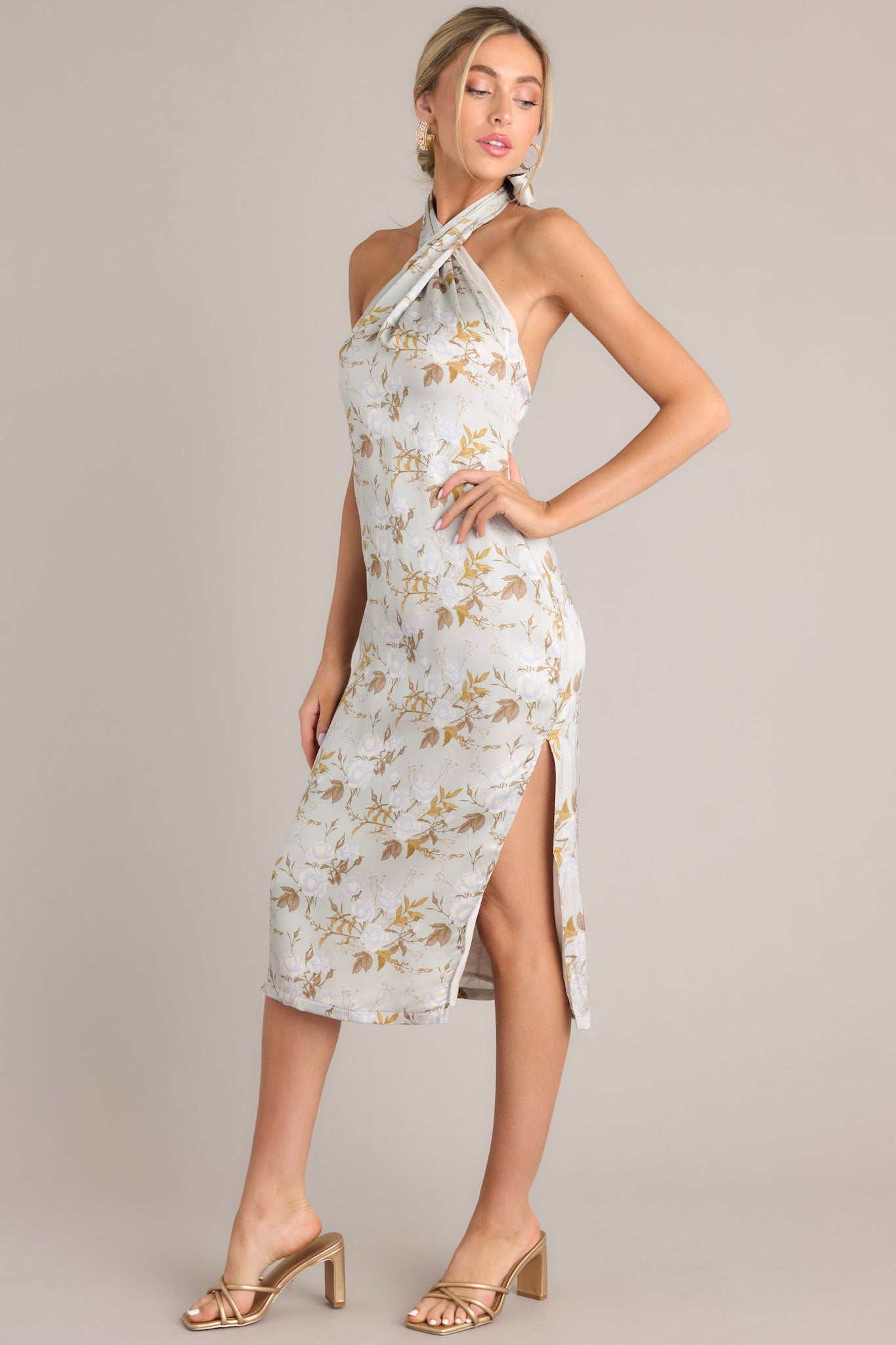 Side view of this light sage midi dress that features a self-tie halter neckline, an open back, a discrete back zipper, a soft material, and a side slit