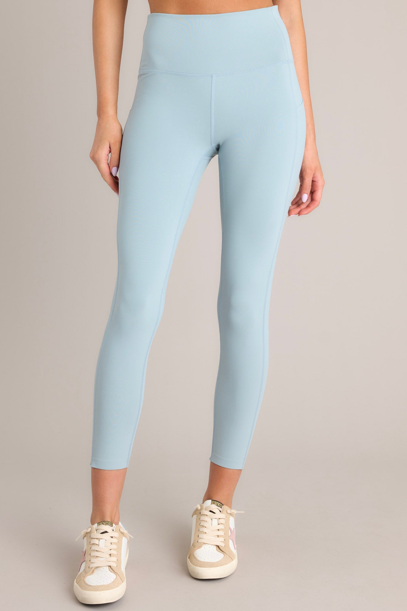 Front view of these leggings that feature a seamless waistband and bottoms, side pockets, and a high waisted design.