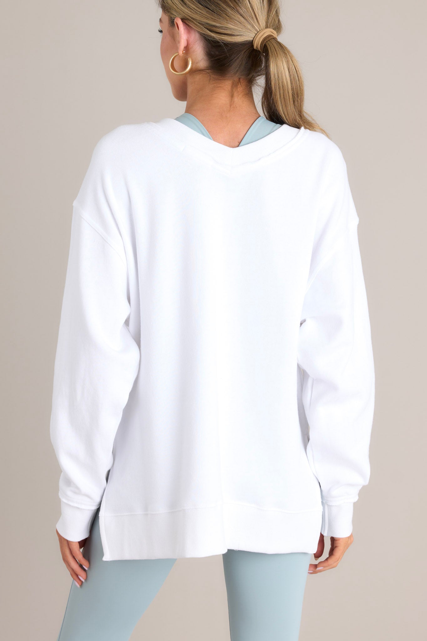 Back view of this sweatshirt that features a v-neckline, a soft material, a split hemline, and ribbed cuffed sleeves.