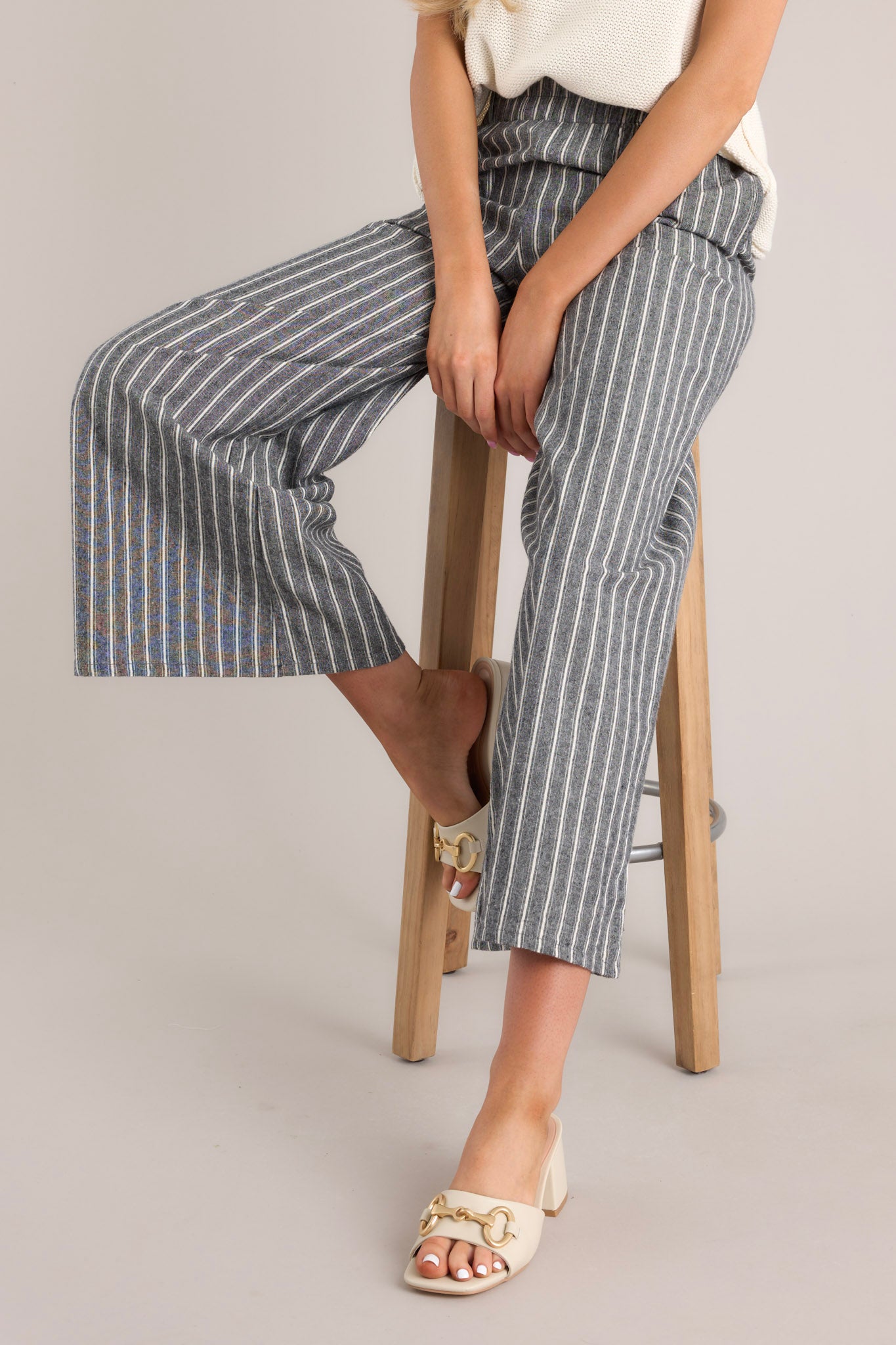 Front angled view of charcoal striped pants featuring a high rise with an elastic waistband, belt loops, an optional self-tie belt, functional pockets, and a wide leg design