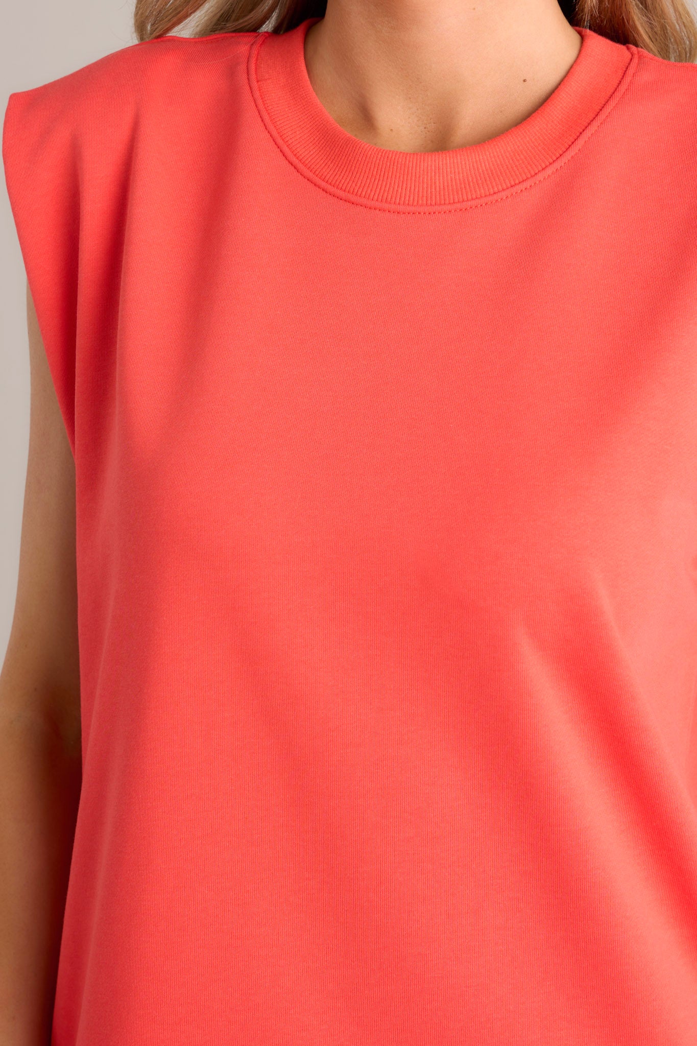 Close up view of this red mini dress that features a scoop neckline, cap sleeves, a bold red color, a cotton fabric and a mini length.