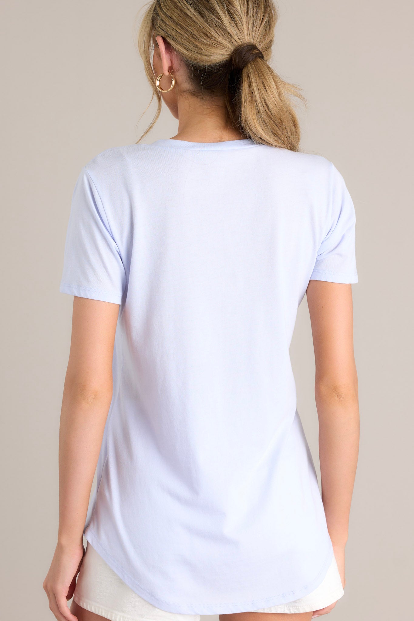 Back view of this vibrant iris tee with a v-neckline, practical chest pocket, ultra-soft fabric, and a gracefully scooped hemline.