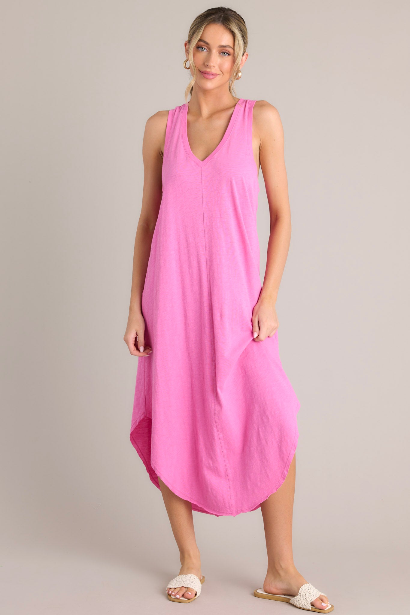 Full front view of this dress that features a v-neckline, a seam down the front and back, a soft lightweight material, and a scoop hemline.