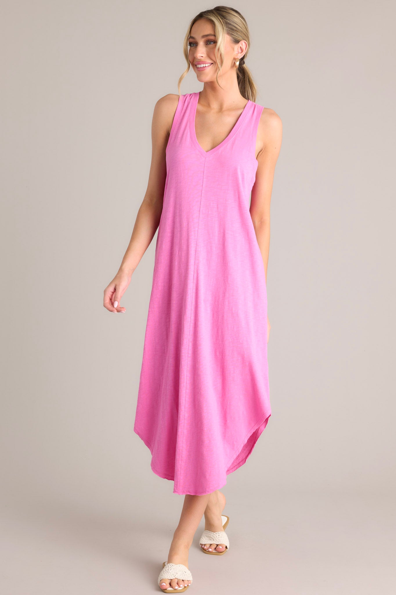 Front view of this dress that features a v-neckline, a seam down the front and back, a soft lightweight material, and a scoop hemline.