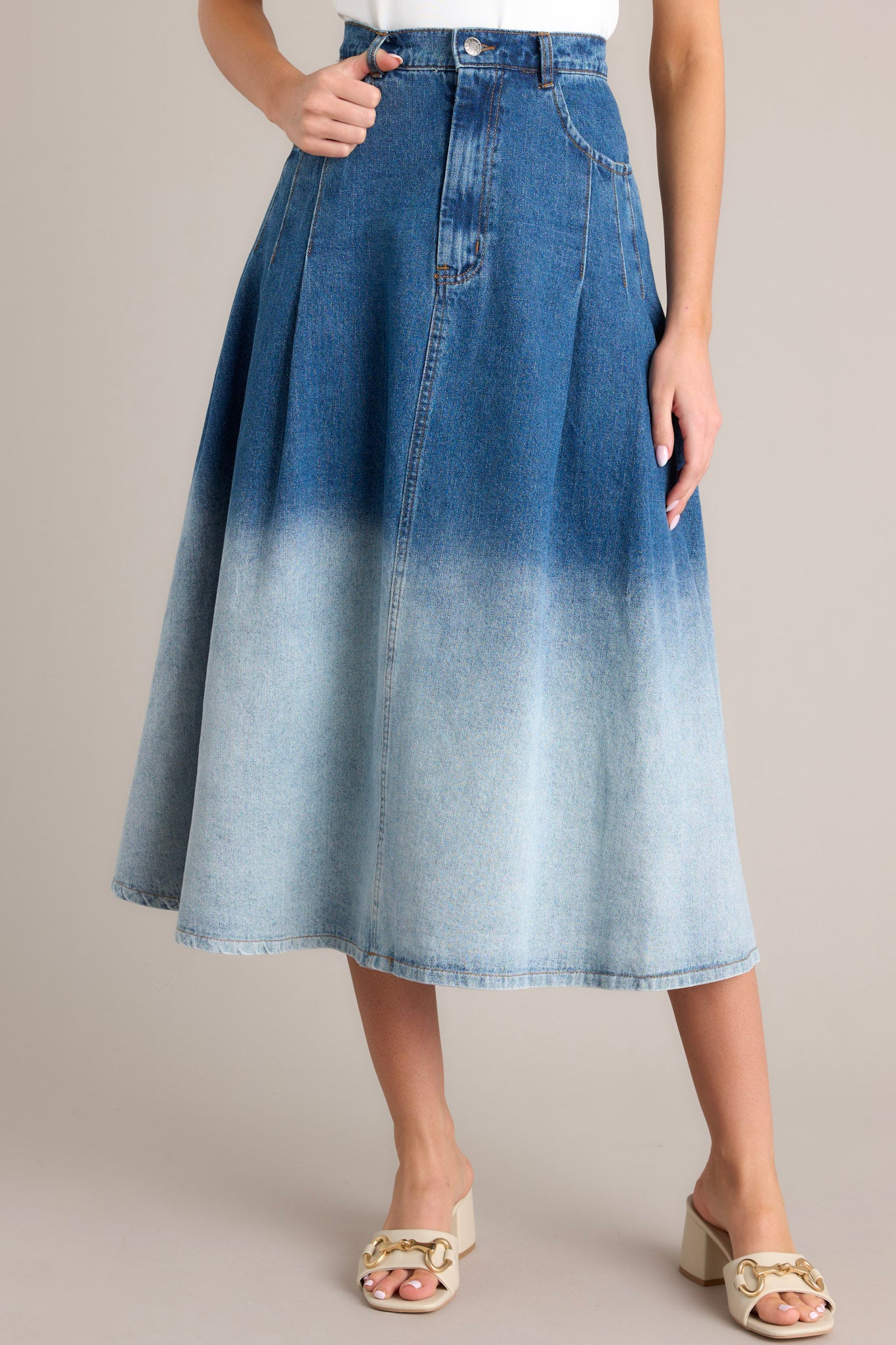 This skirt features a high waisted design, a classic button &amp; zipper closure, belt loops, functional front pockets, subtle pleats, and an ombré gradient.