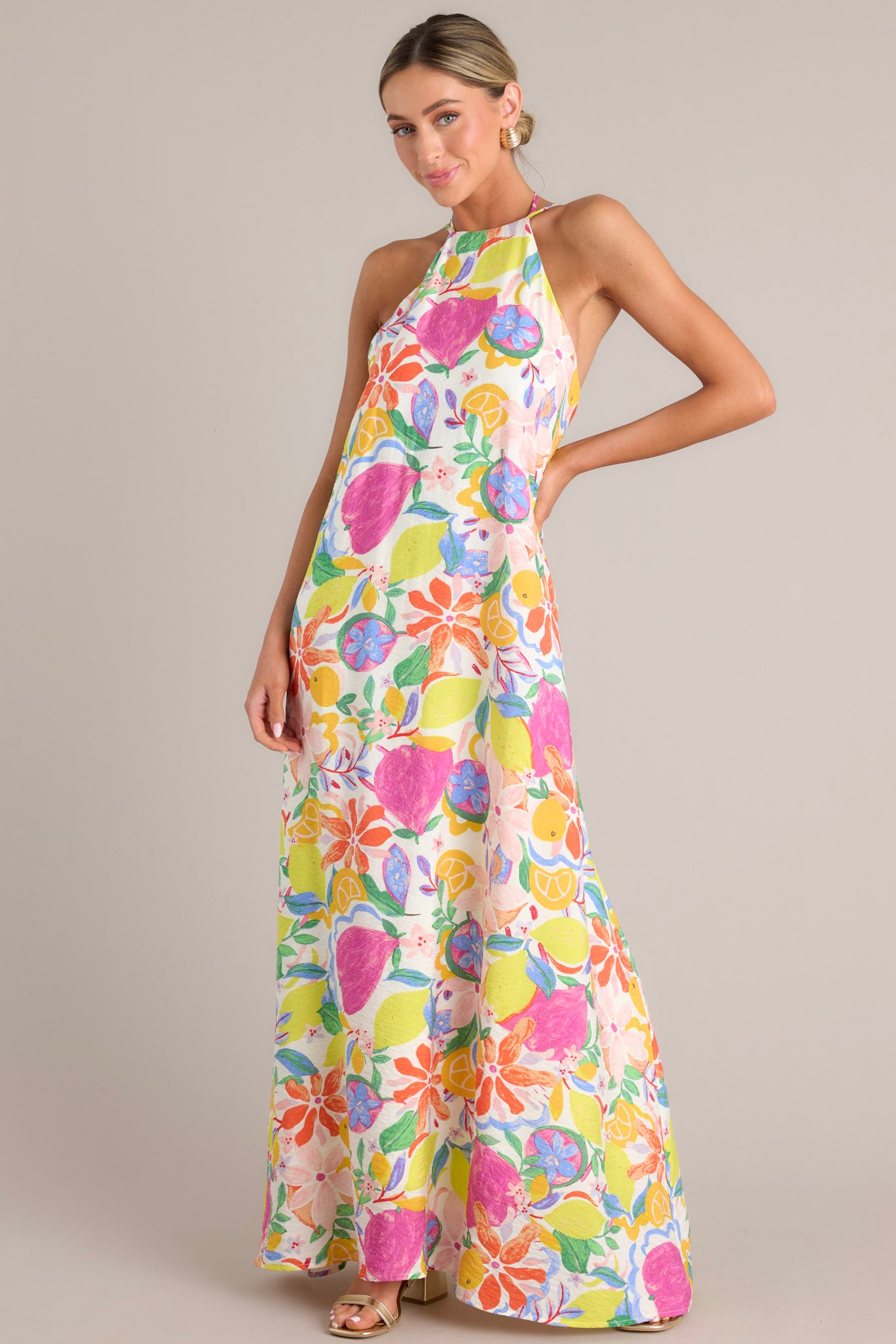 Multi-floral print dress with self-tie halter neckline, adjustable thin straps, open back, self-tie waist belt, and flowing silhouette.