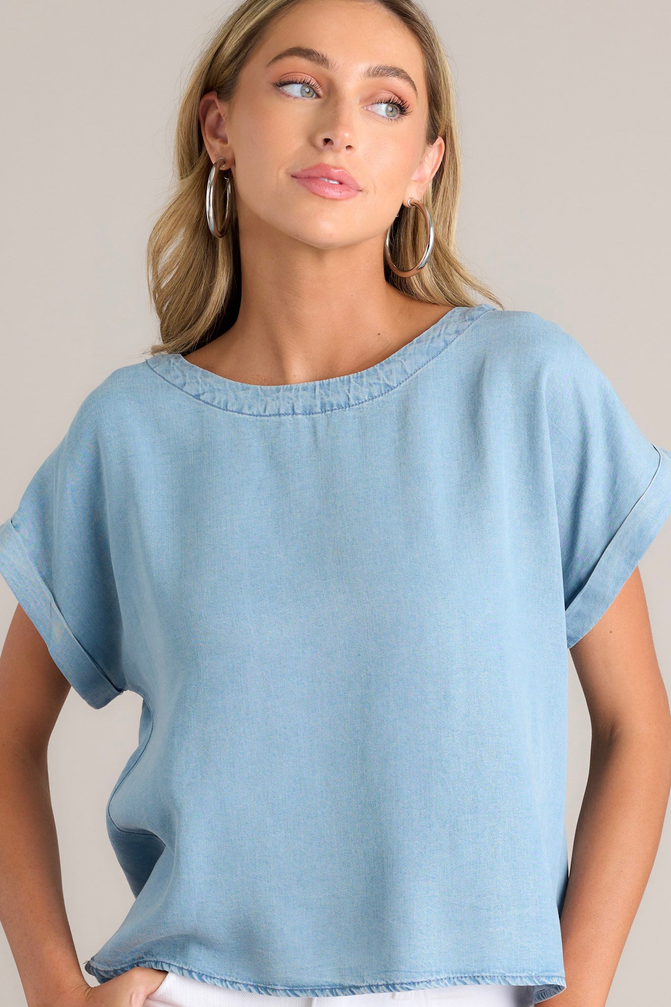 Front view of this light chambray top that features a crew neckline, a relaxed fit, and a wide cuffed short sleeves.