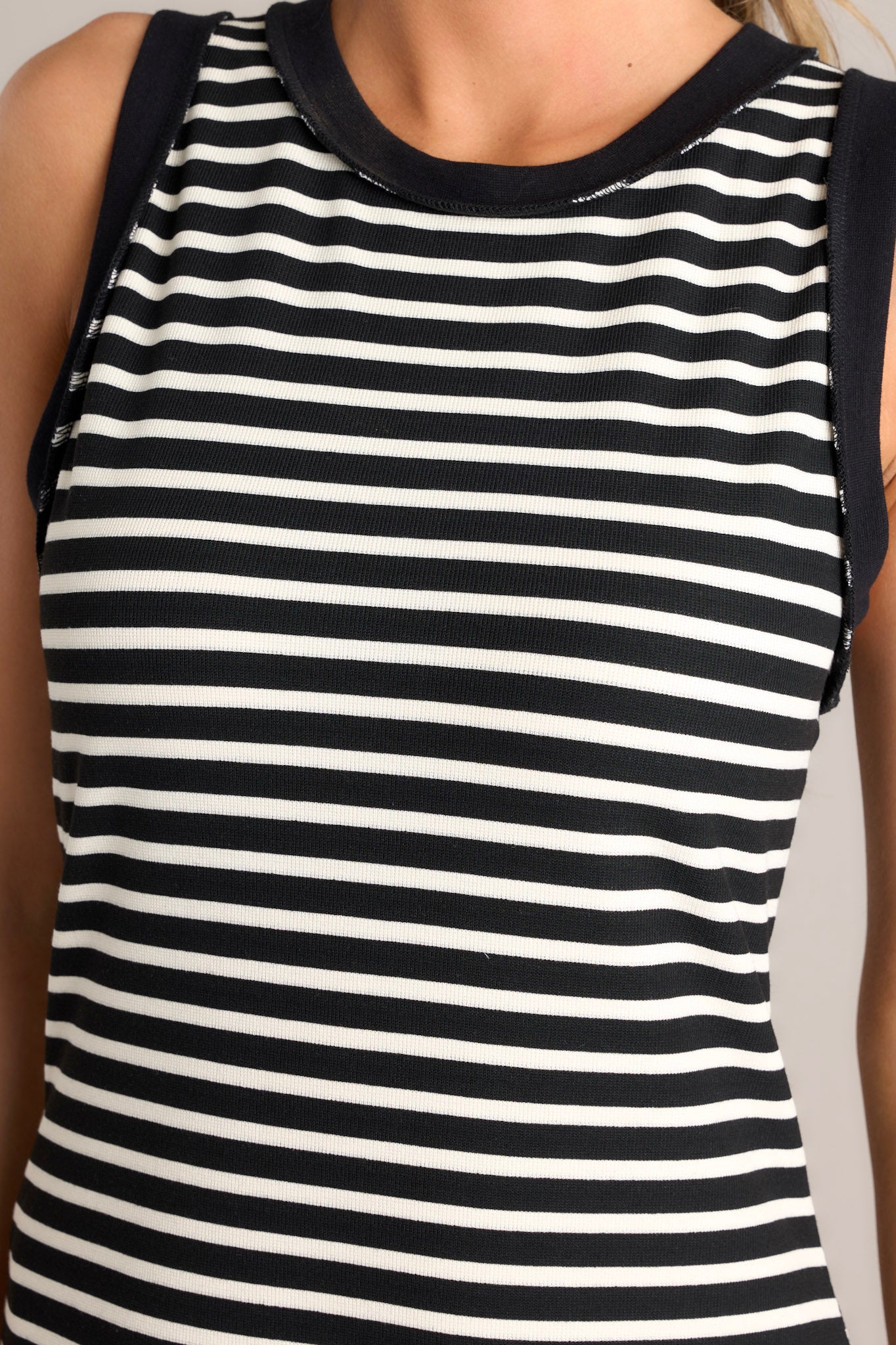 Close up view of this black stripe midi dress that features a crew neckline, a classic horizontal stripe design, and a split hemline.