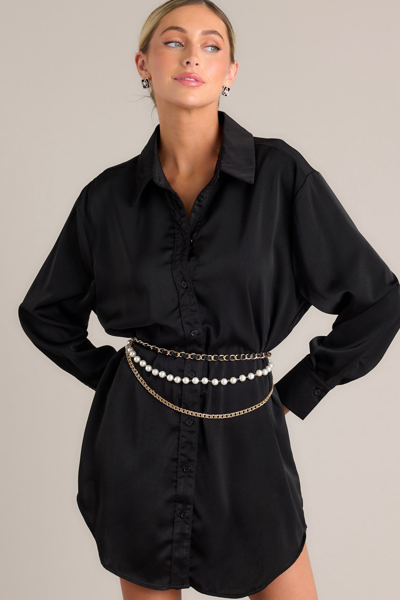 Front view of this mini dress that features a collared neckline, functional buttons down the front, buttoned cuffed long sleeves, and a satin-like material.