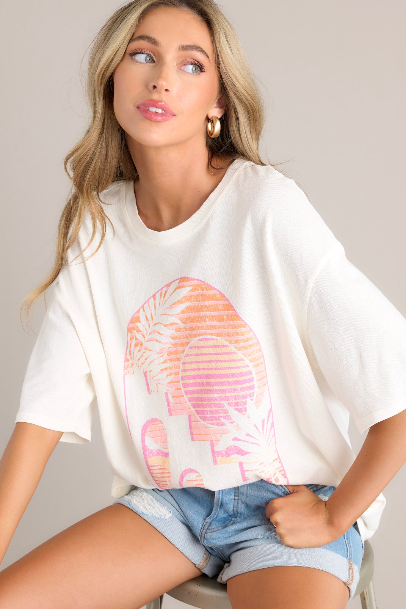 Angled close up view of this tee with crew neckline, summer-themed graphic, oversized fit, wide half sleeves.