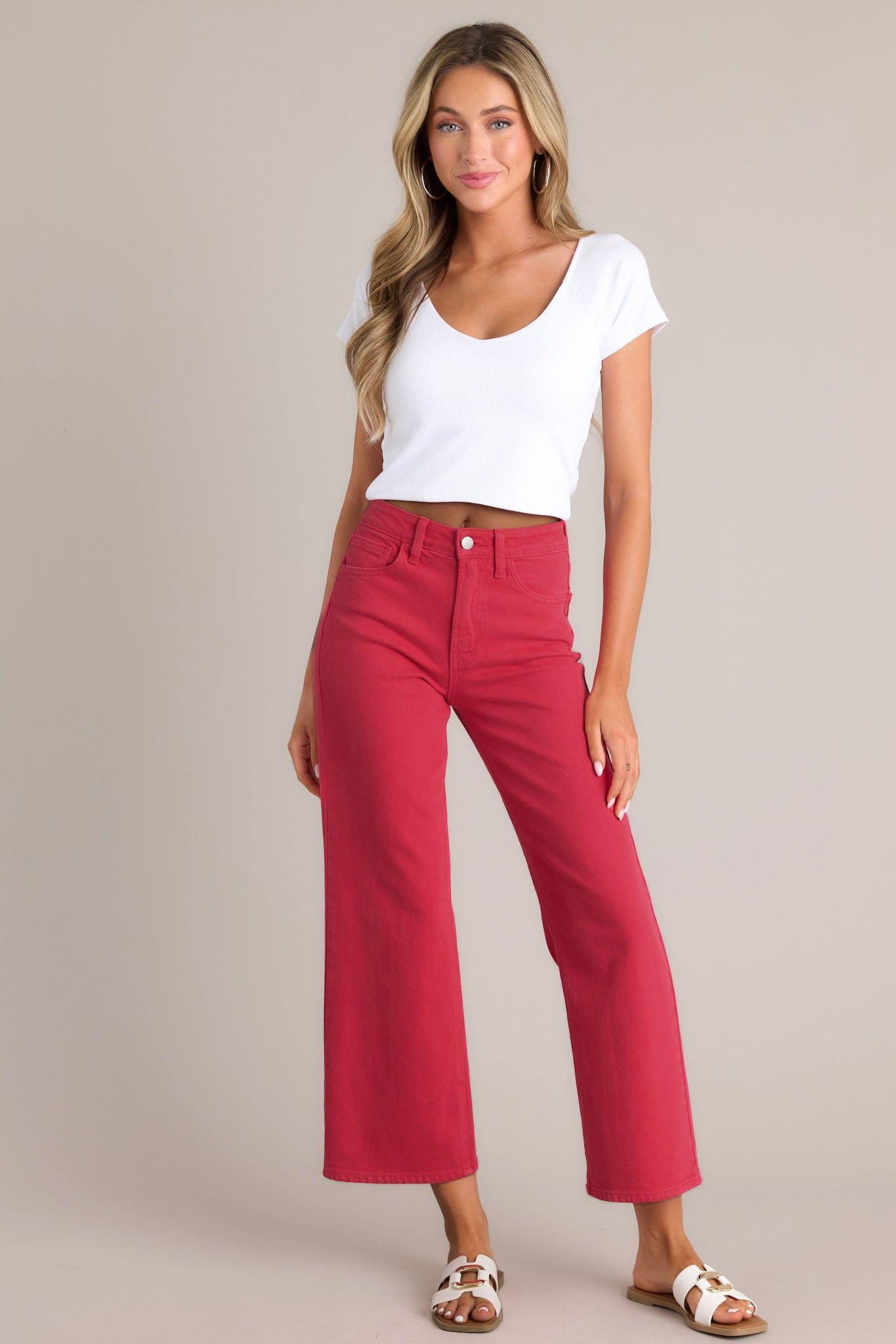 Full front view of these red jeans that feature a high waisted design, classic button & zipper closure, belt loops, functional front & back pockets, and a cropped length.