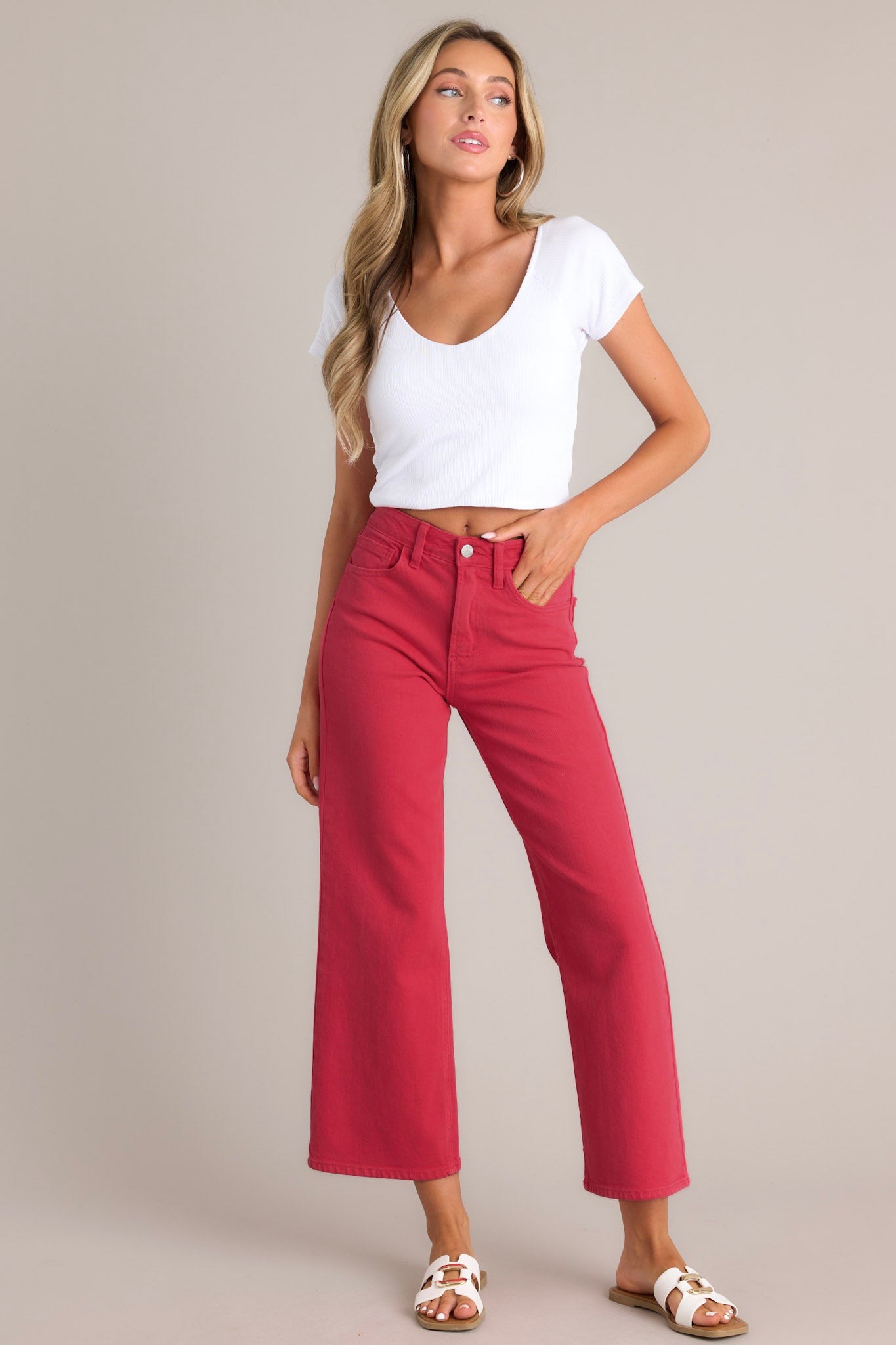 Full body view of these red jeans that feature a high waisted design, classic button & zipper closure, belt loops, functional front & back pockets, and a cropped length.