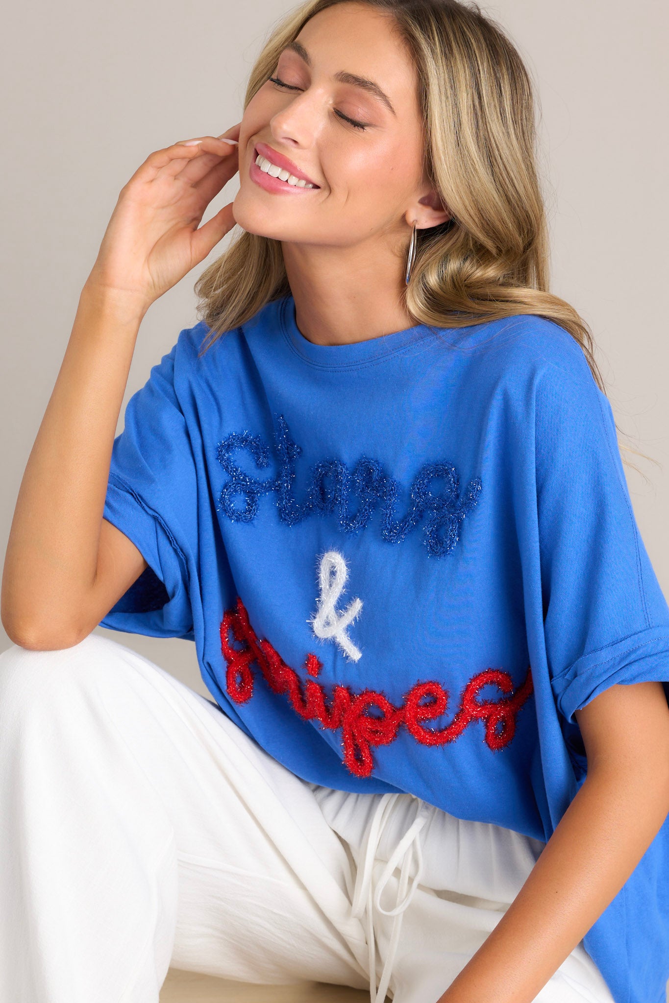 This blue top features a crew neckline, textured 3D writing, an extremely oversized fit, and cuffed wide short sleeves.