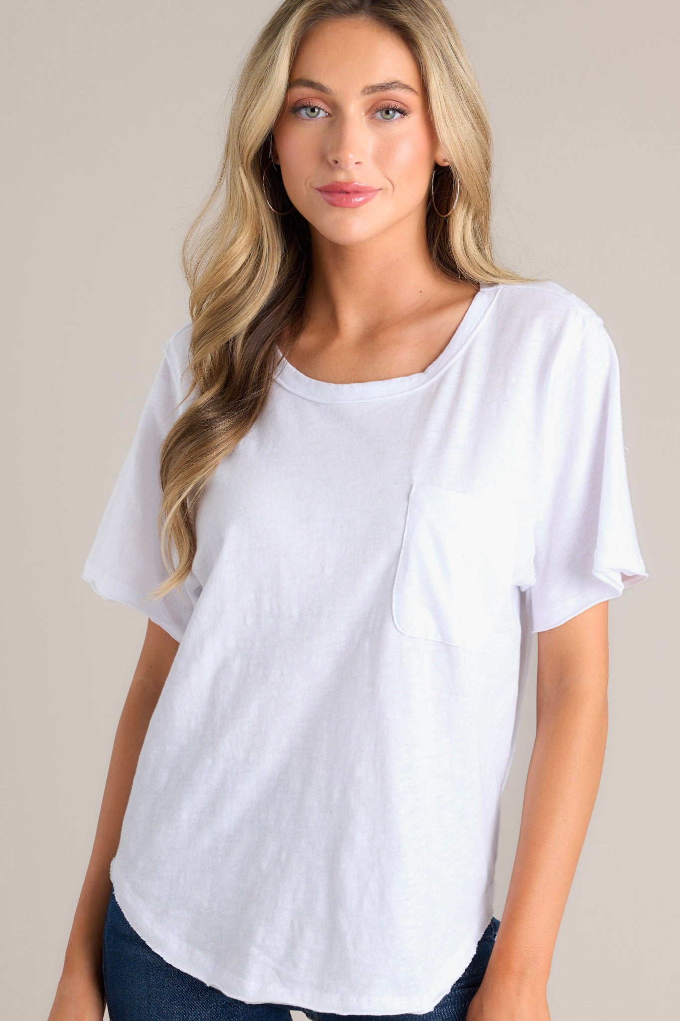 Front view of this white tee that features a crew neckline, a functional breast pocket, a raw hemline, and short sleeves.