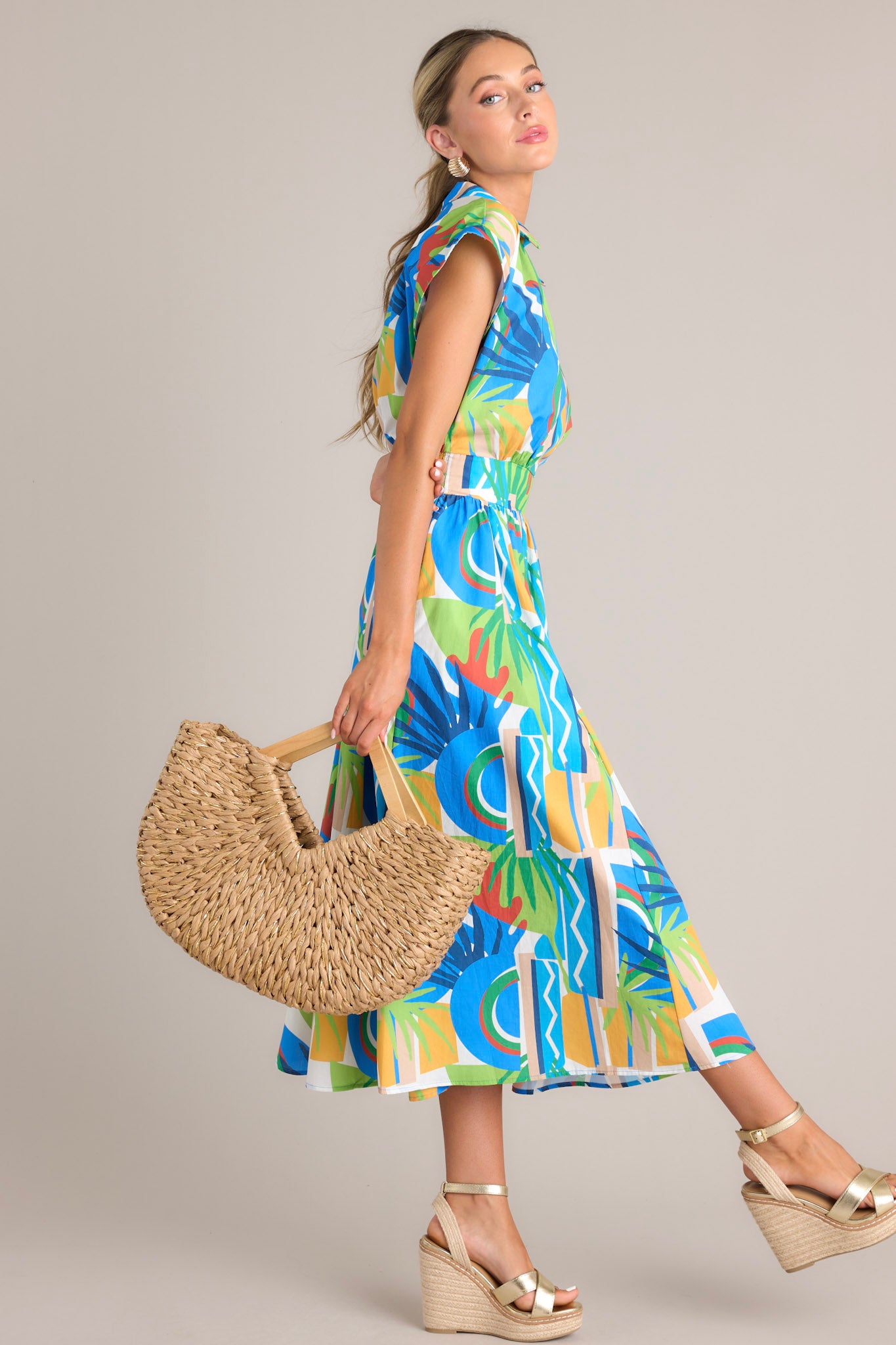 Side view of a colorful wrap dress showcasing an abstract design in blue, green, yellow, and red, with a cinched waist and cap sleeves