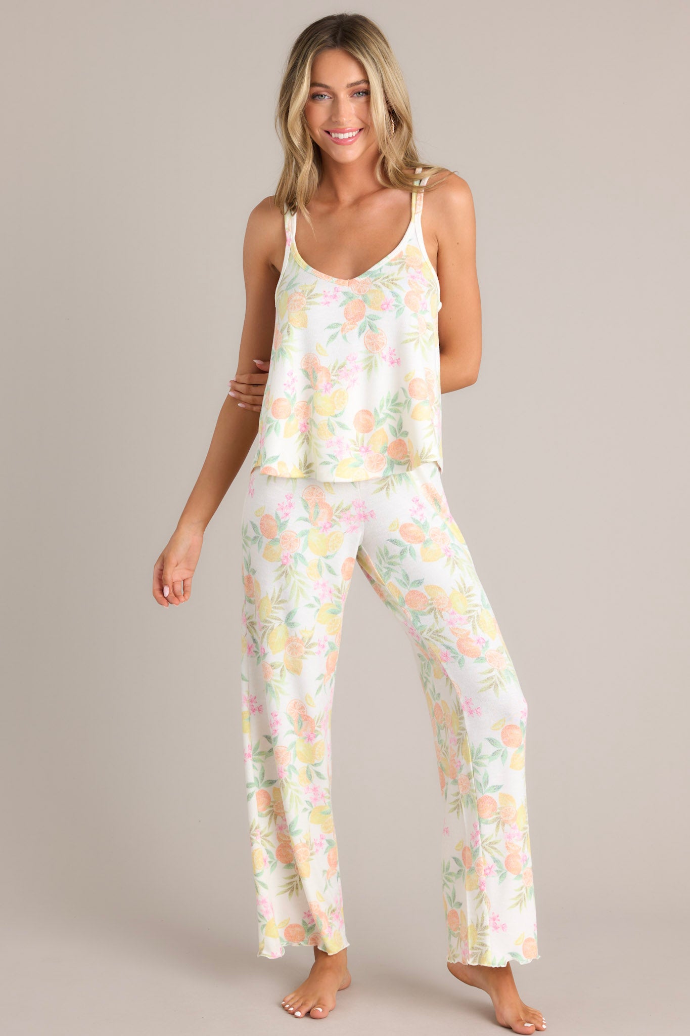 Full body view of these white citrus pants that feature a high waisted design, a fully smocked waistband, a super soft material, a wide leg, and a scalloped hemline.