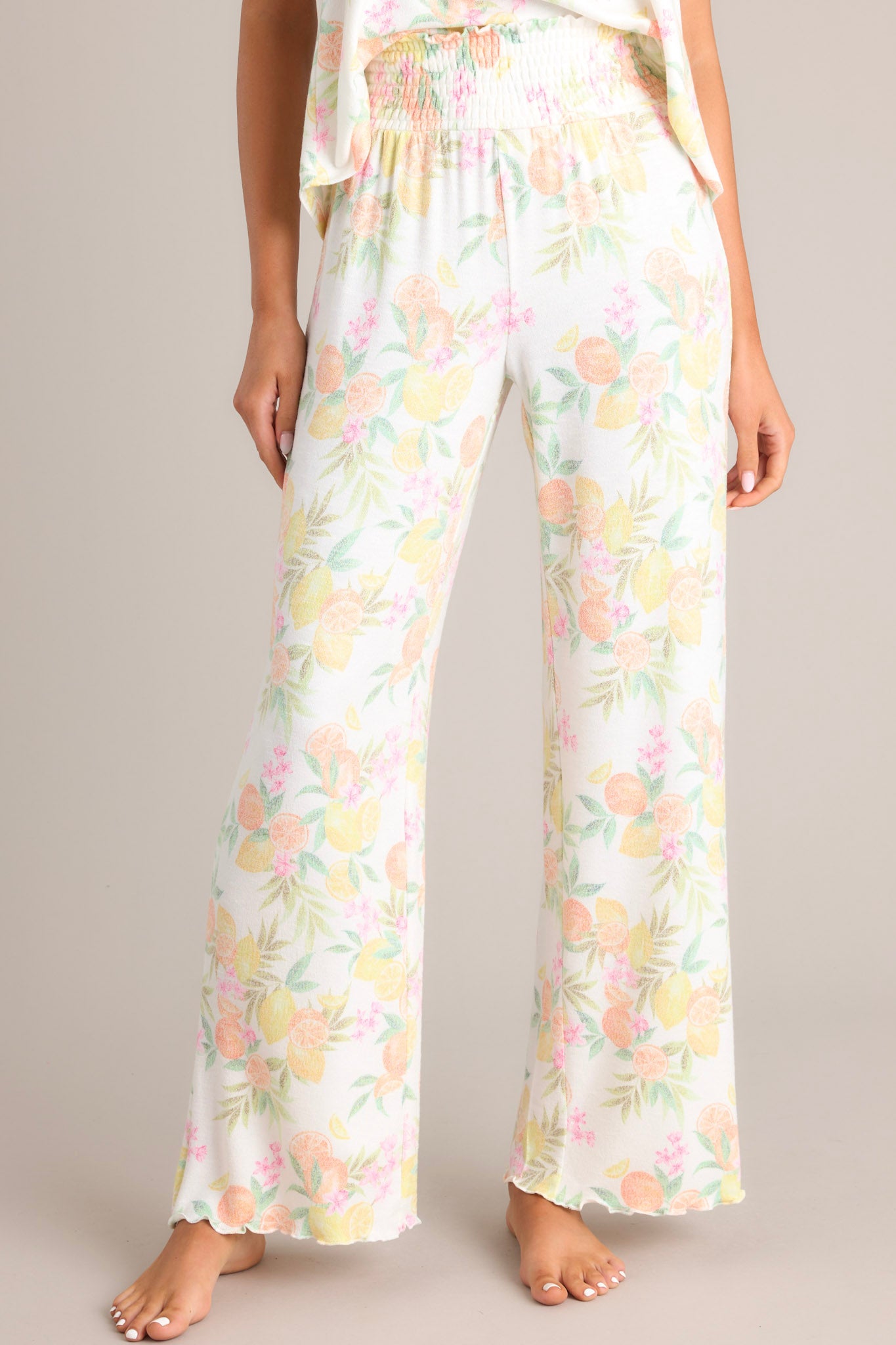 These white citrus pants feature a high waisted design, a fully smocked waistband, a super soft material, a wide leg, and a scalloped hemline.