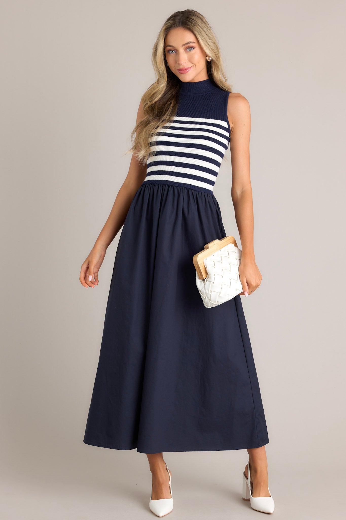 Sleeveless navy and white striped dress with a fitted bodice and a flared skirt.