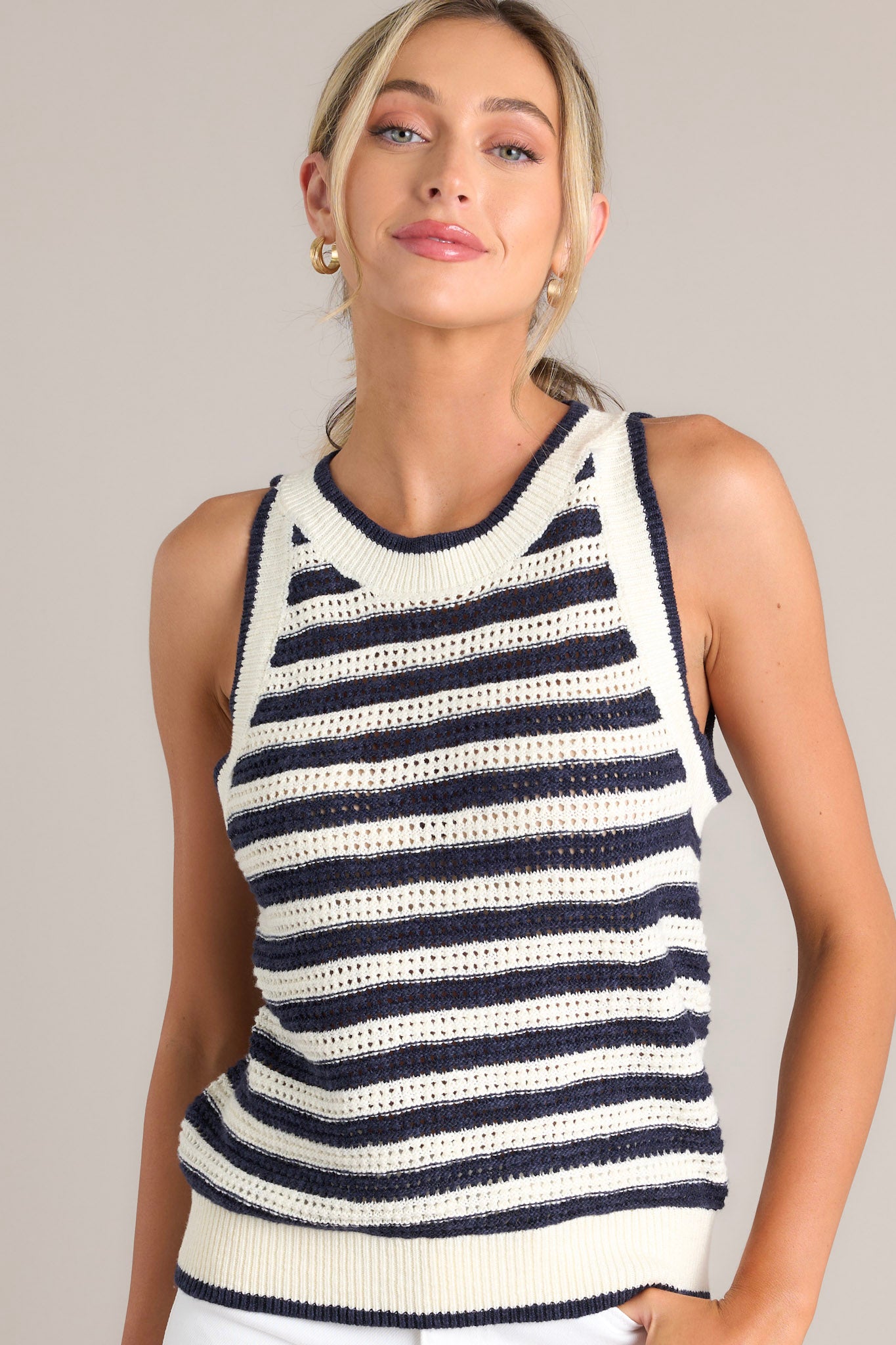 Front view of this navy stripe tank that features a high ribbed neckline, an open knit design, and a ribbed hemline.