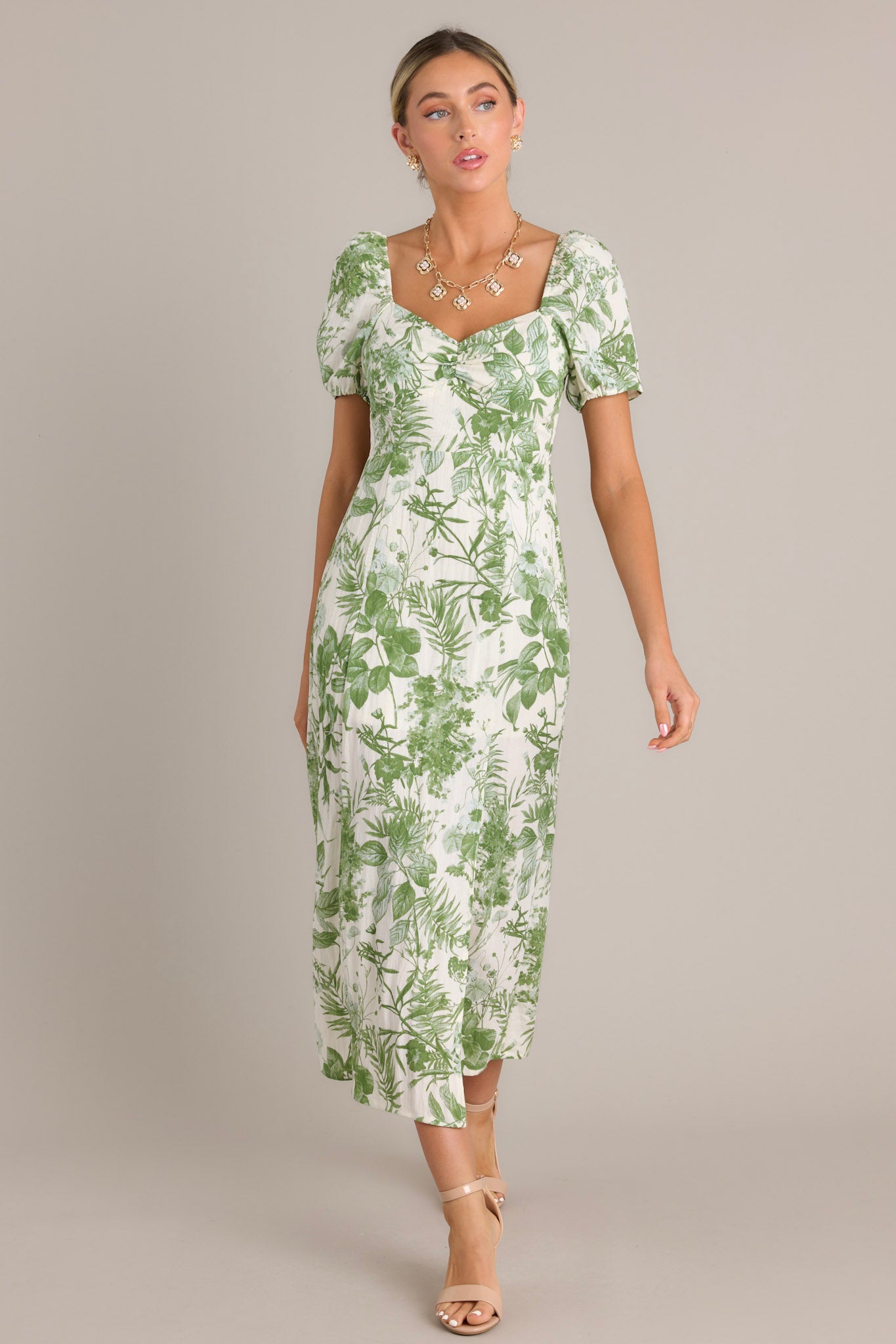 Elegant green floral midi dress with short puff sleeves, a sweetheart neckline, a fitted bodice, a cinched waist, and a mid-length skirt with a front slit.